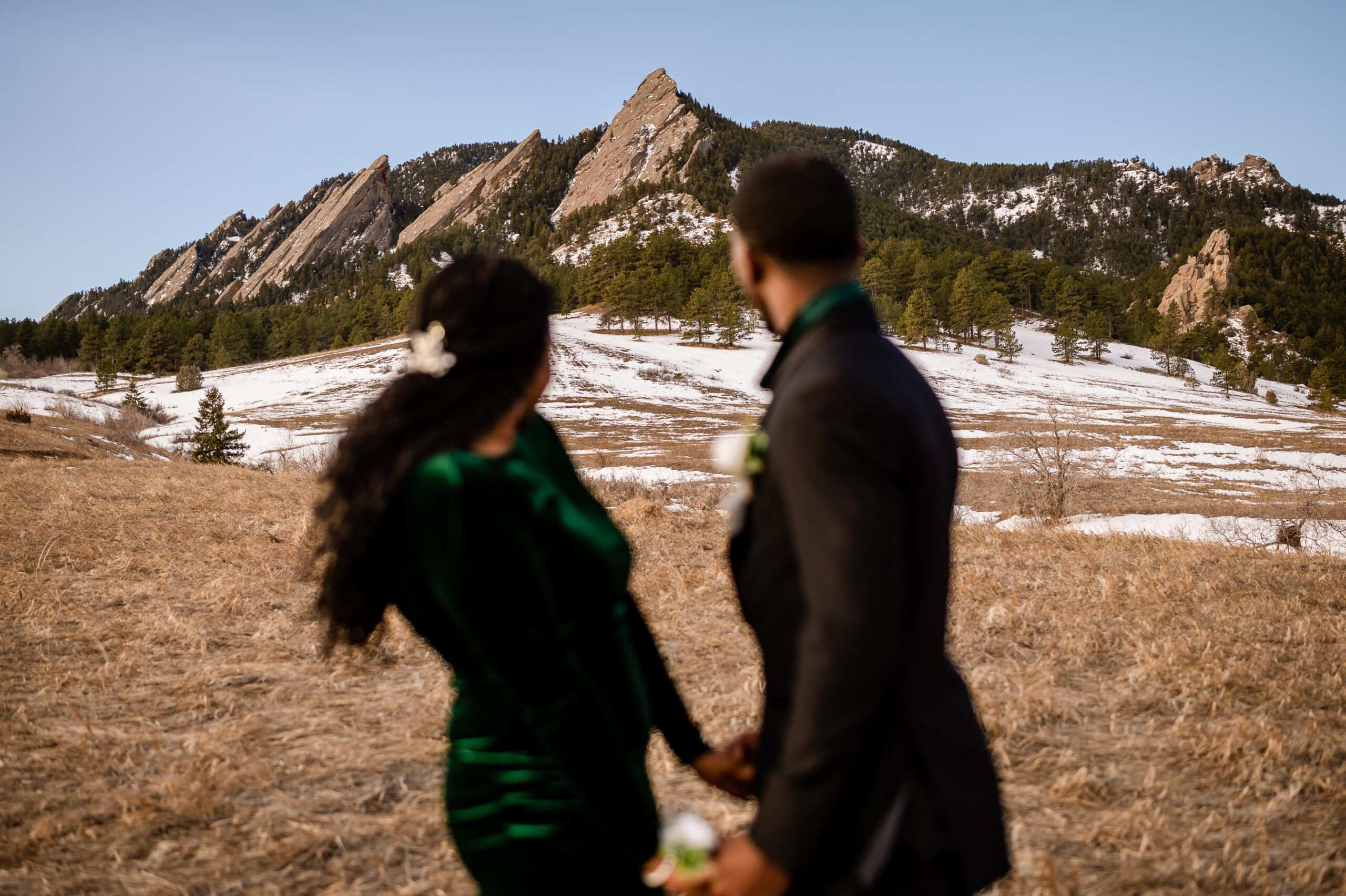 bride and groom looking towrads the mountains behind them at their Chautauqua Trail elopement.