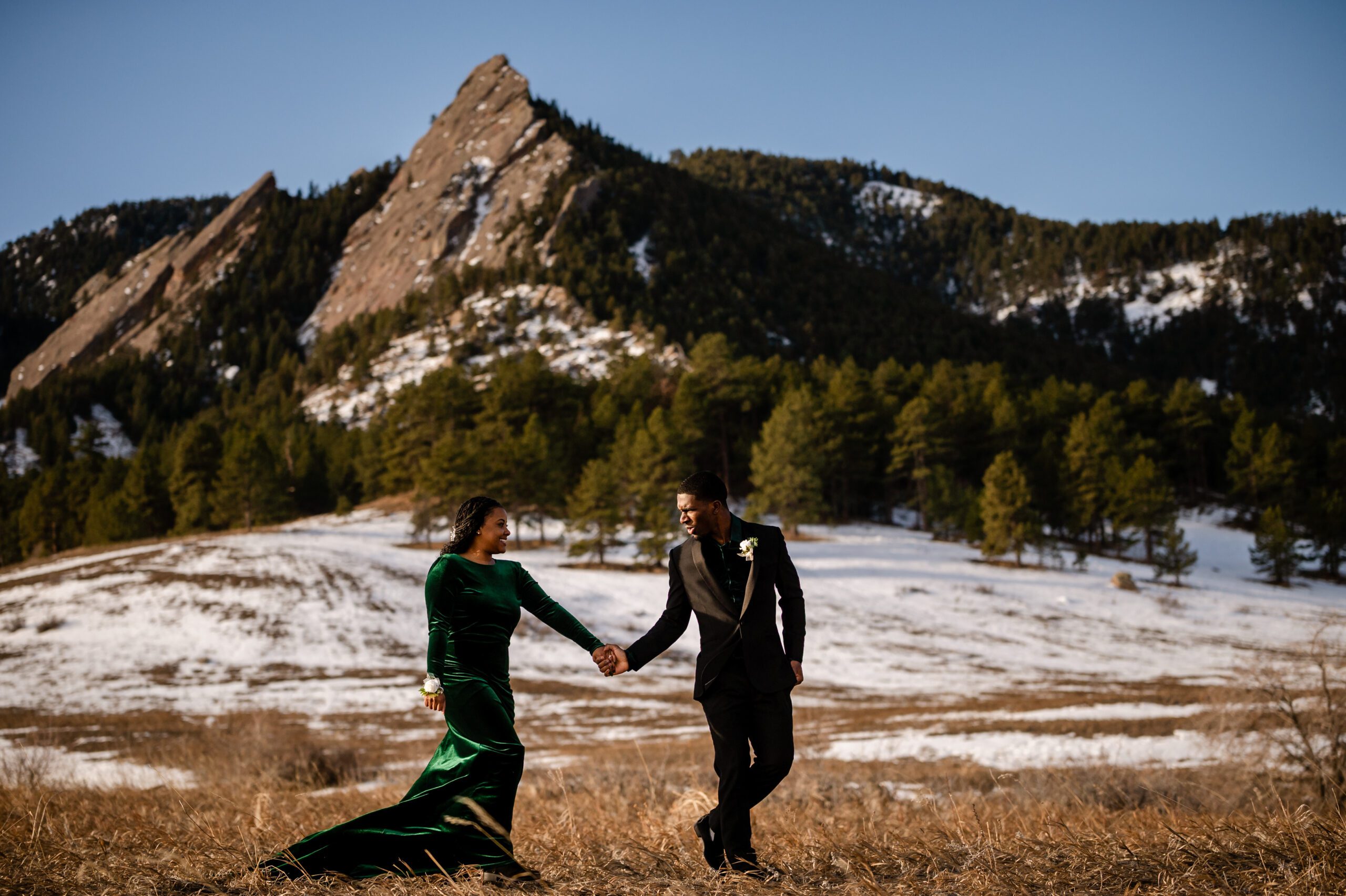 the bride and groom holding hands and walking during their Chautauqua Trail elopement.