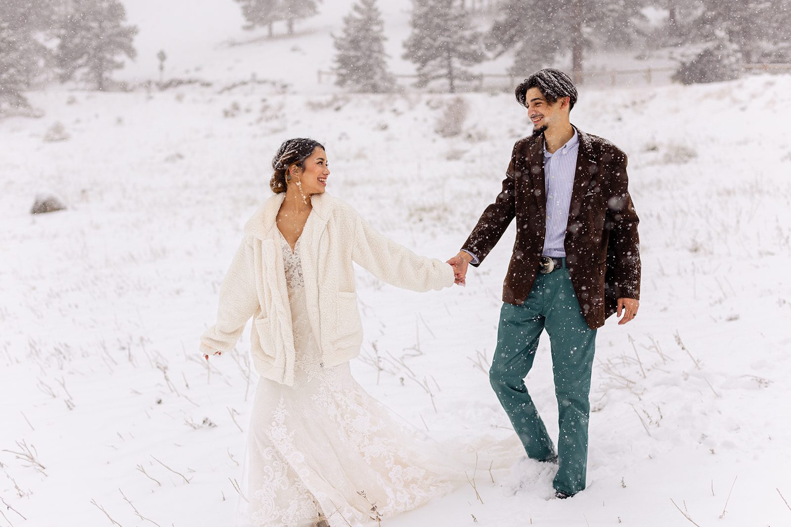 bride walking with groom the snow on flagstaff mountain near Halfway House elopement