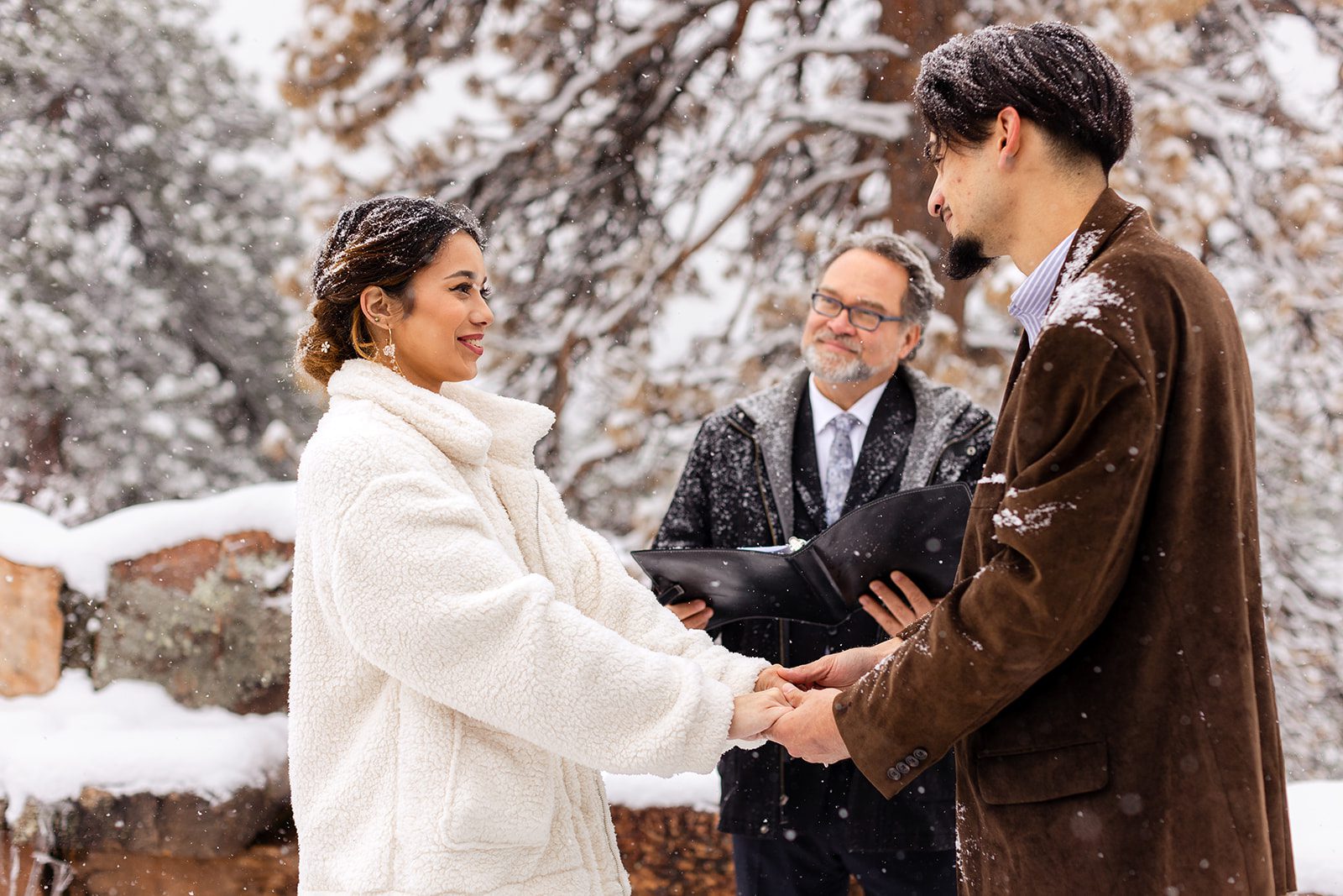 Bride smiling sweetly bundled up in a furry white jacket during her Halfway House elopement ceremony