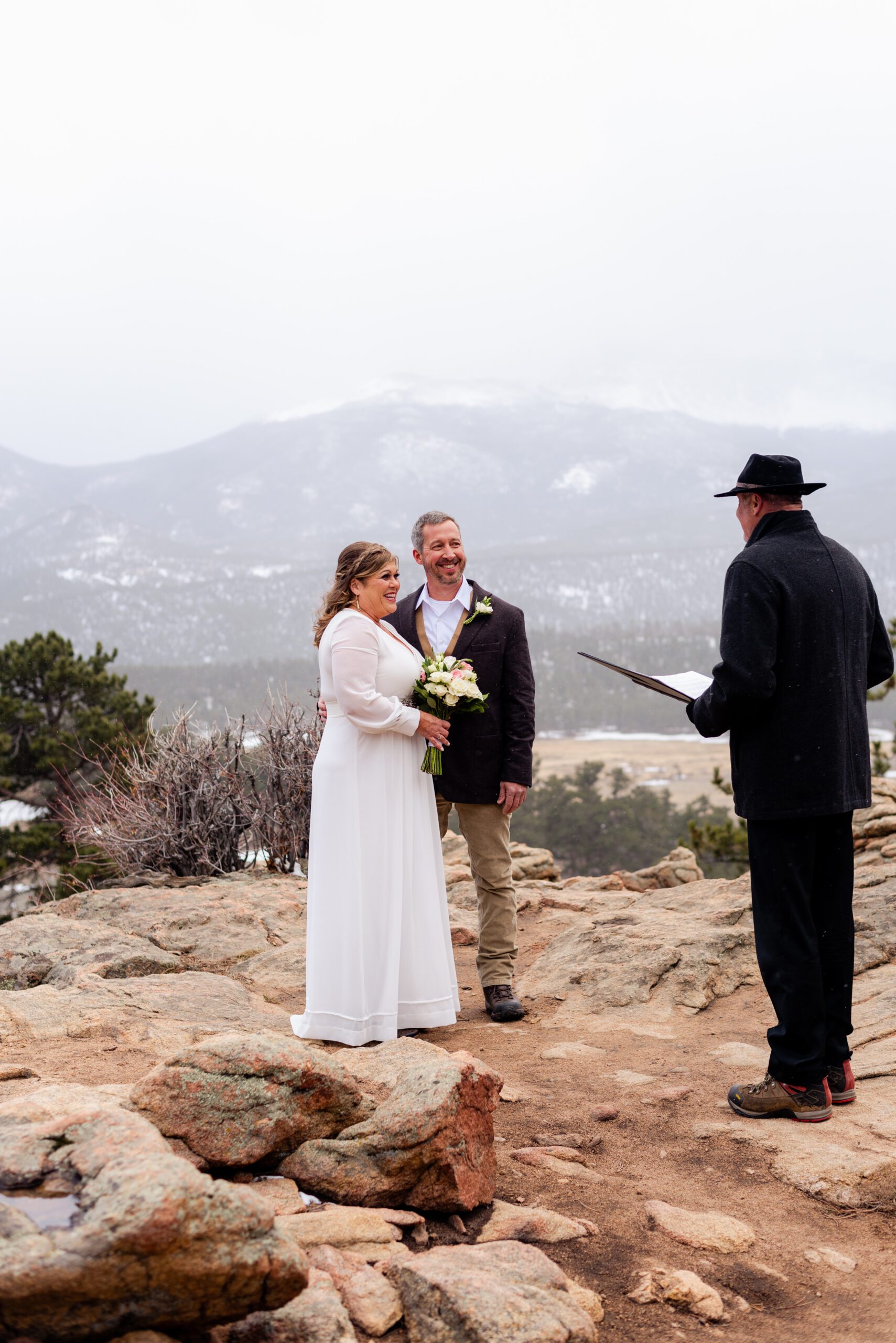 the bride and groom smile at the officiant during their ceremony for their spring elopement at 3M Curve.