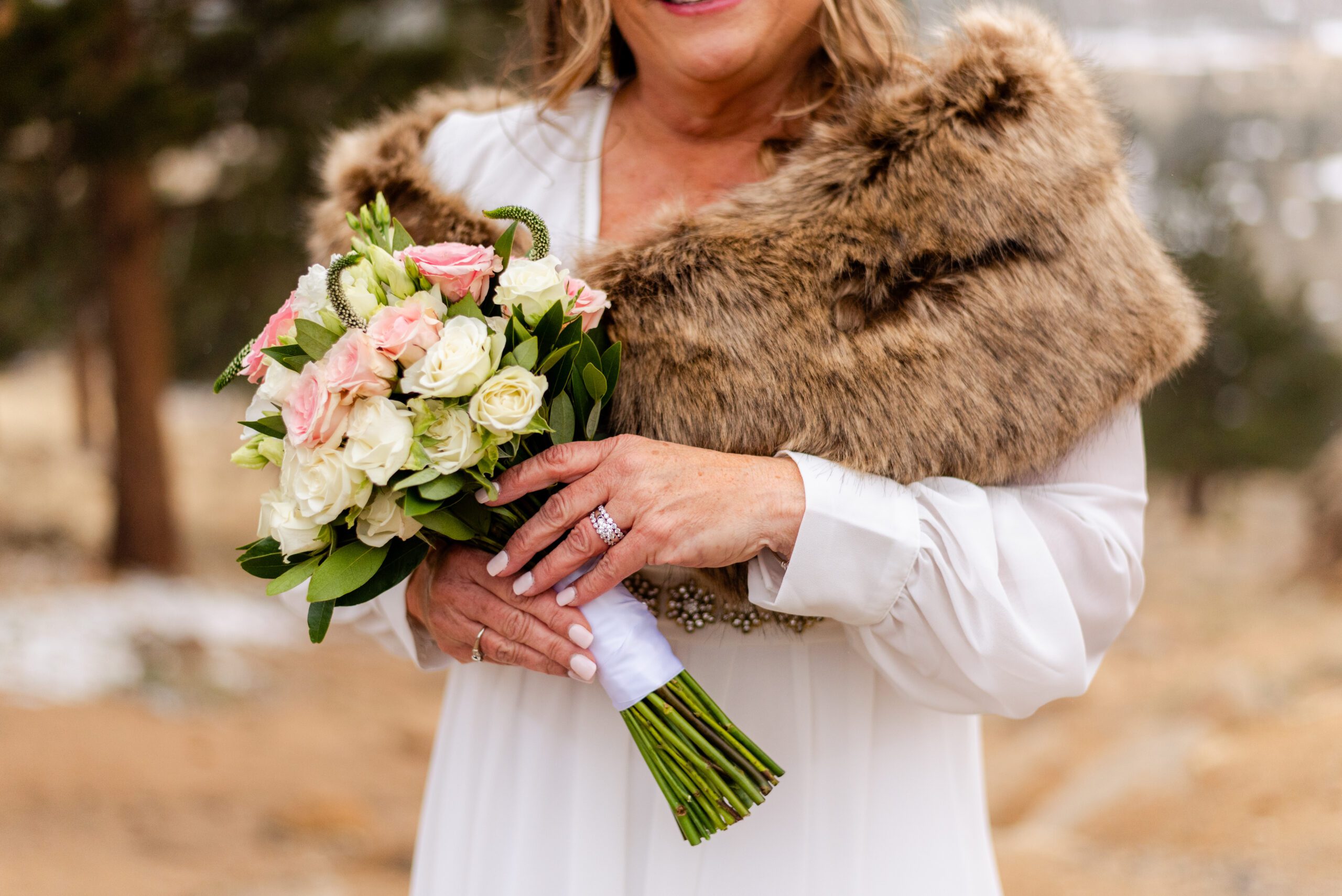 an upclose shot of the bride's bouquet and ring at her spring elopement at 3M Curve.