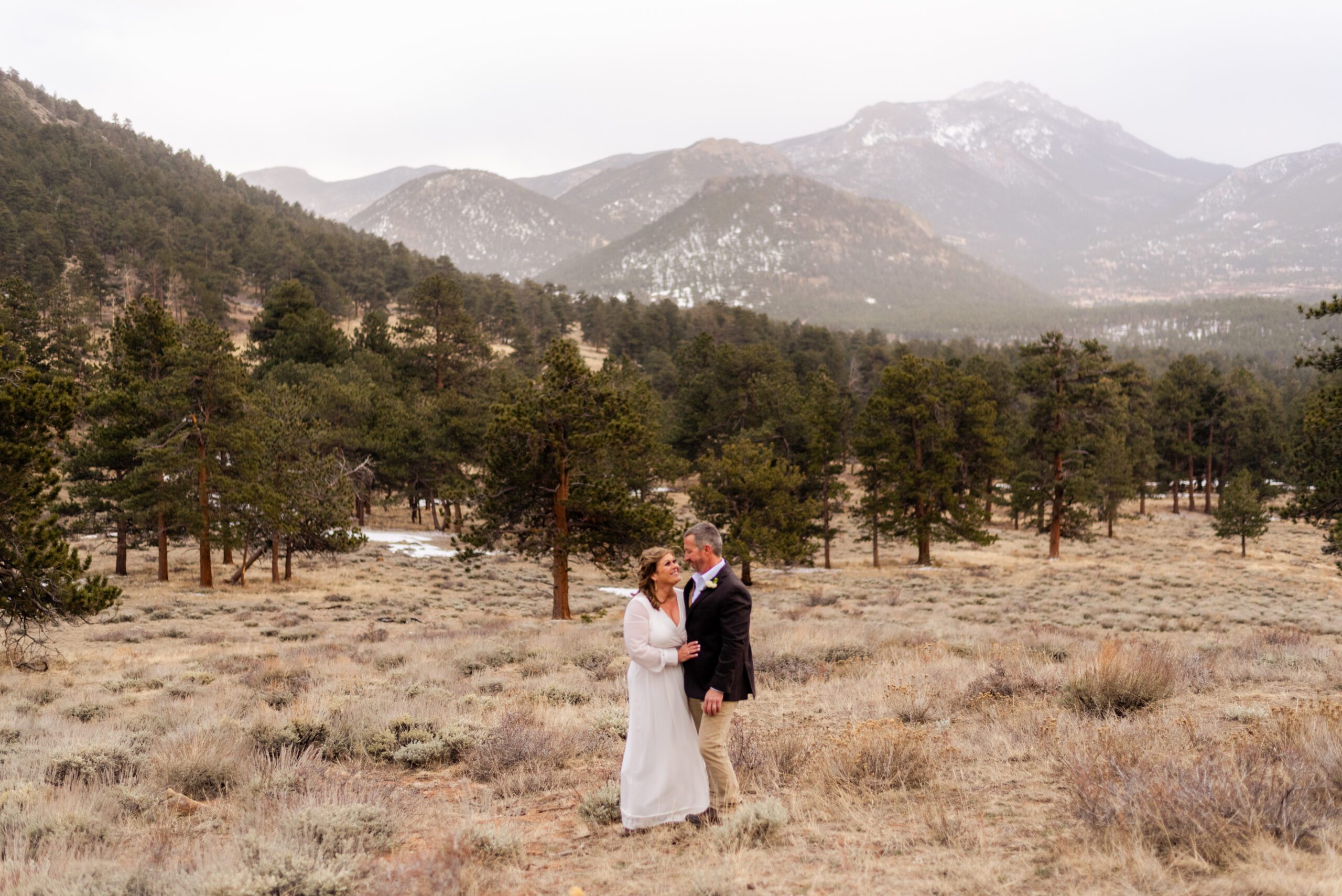 the bride and groom looking at each other with the mountains in the distance at their spring elopement at 3M Curve.