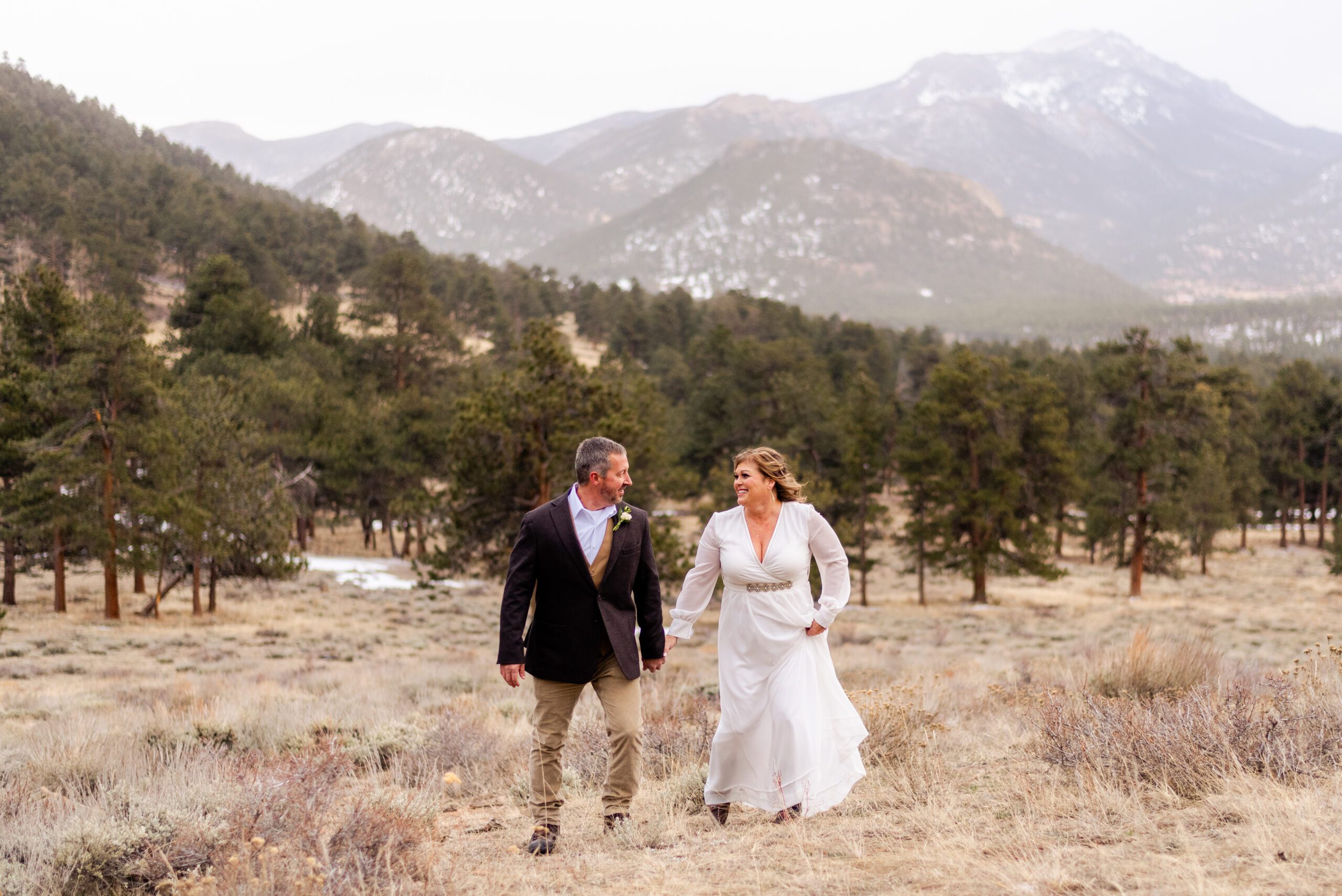 the bride and groom walking in the meadow at their spring elopement at 3M Curve.