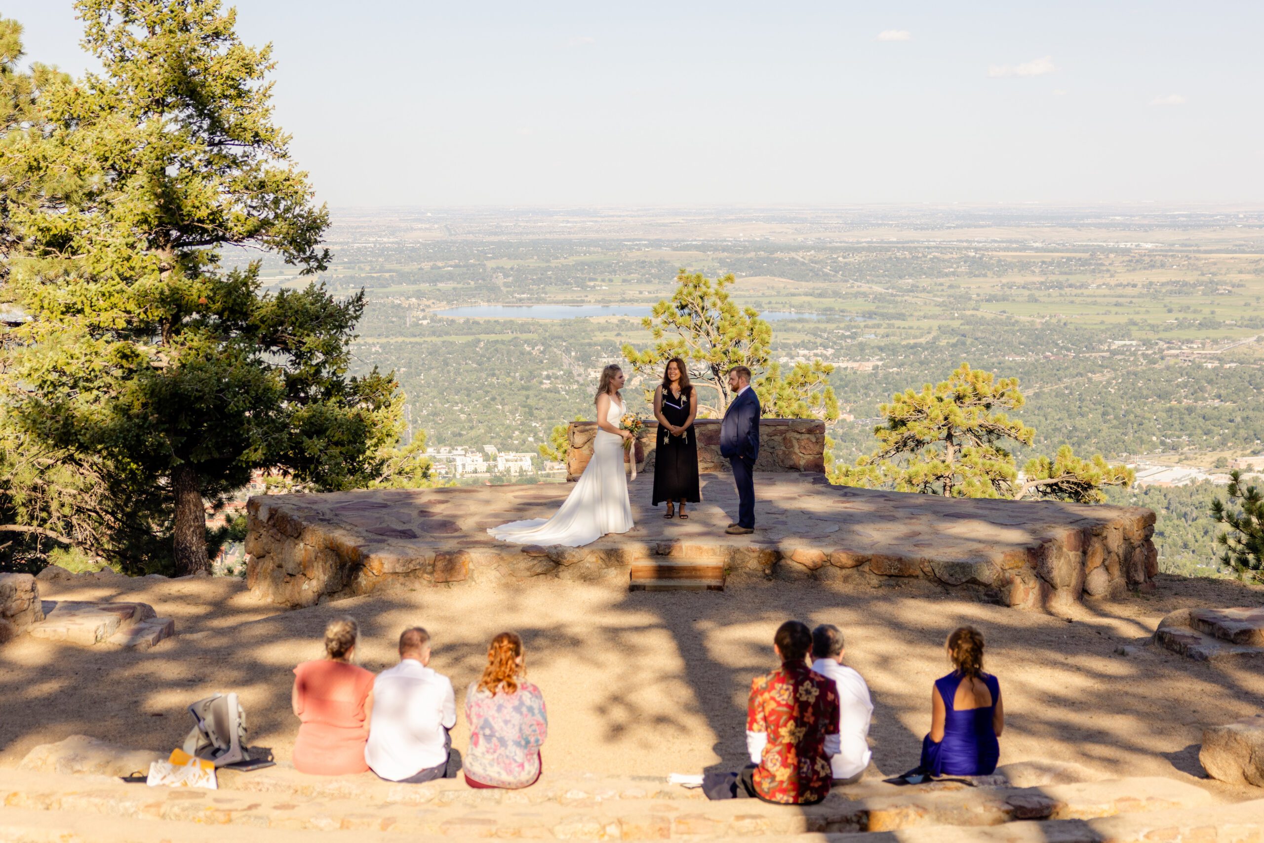 The Sunrise Amphitheater wedding ceremony with the bride and groom holding hands in front of their guests.