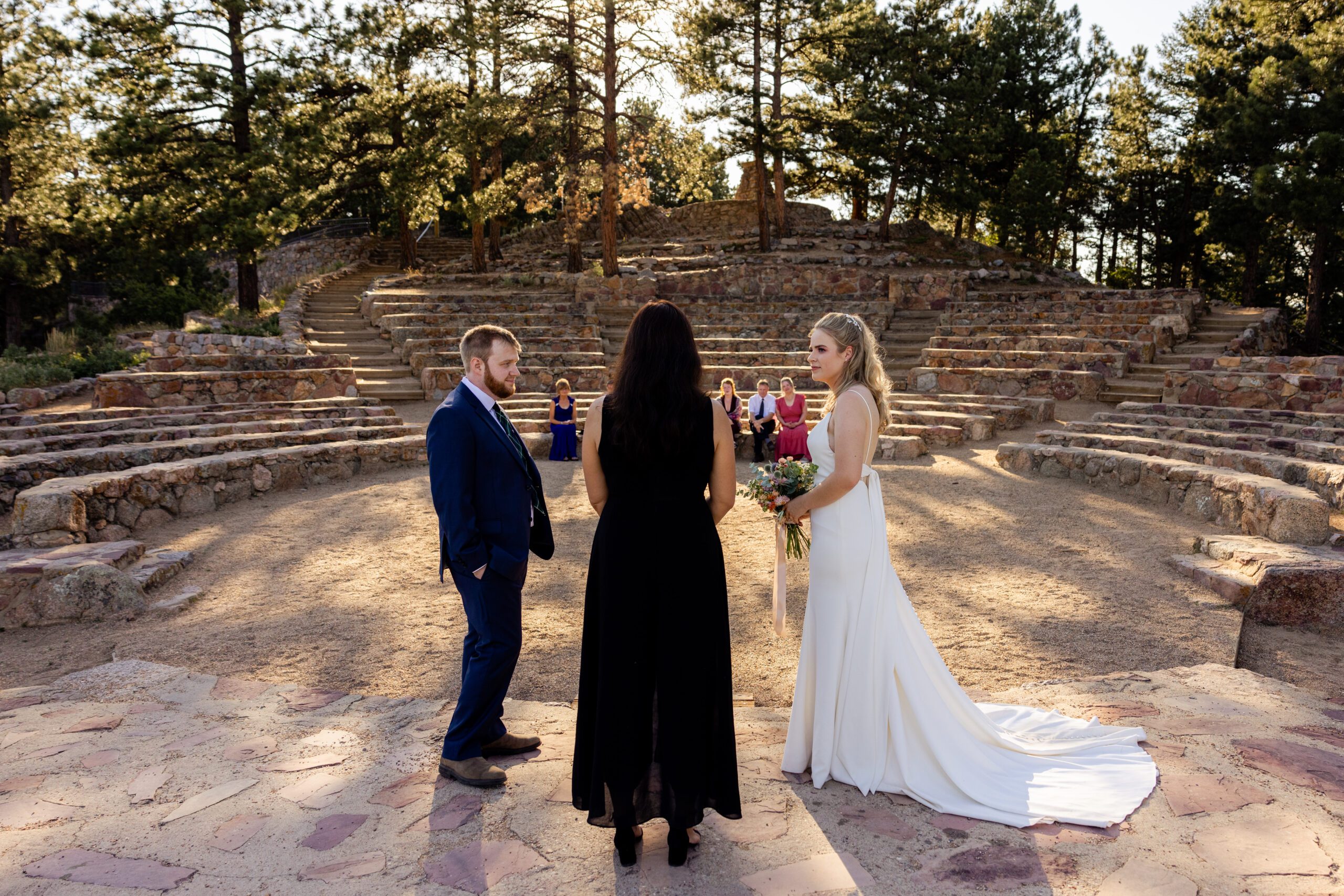 the bride and groom listening to their officiant during their Sunrise Amphitheater wedding.