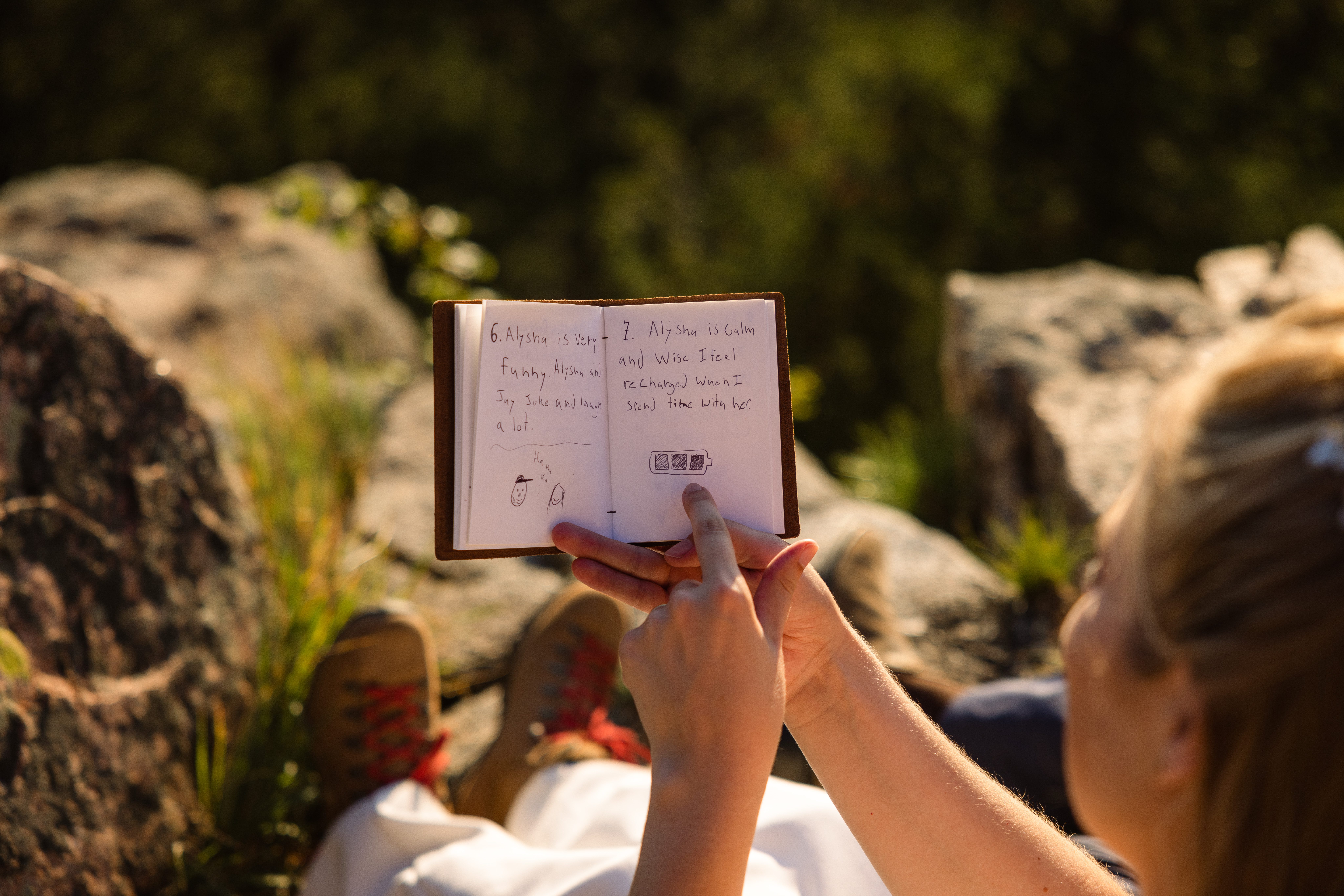 The bride and groom reading notes to each other after on top of the mountain near Sunrise Amphitheater after their wedding.