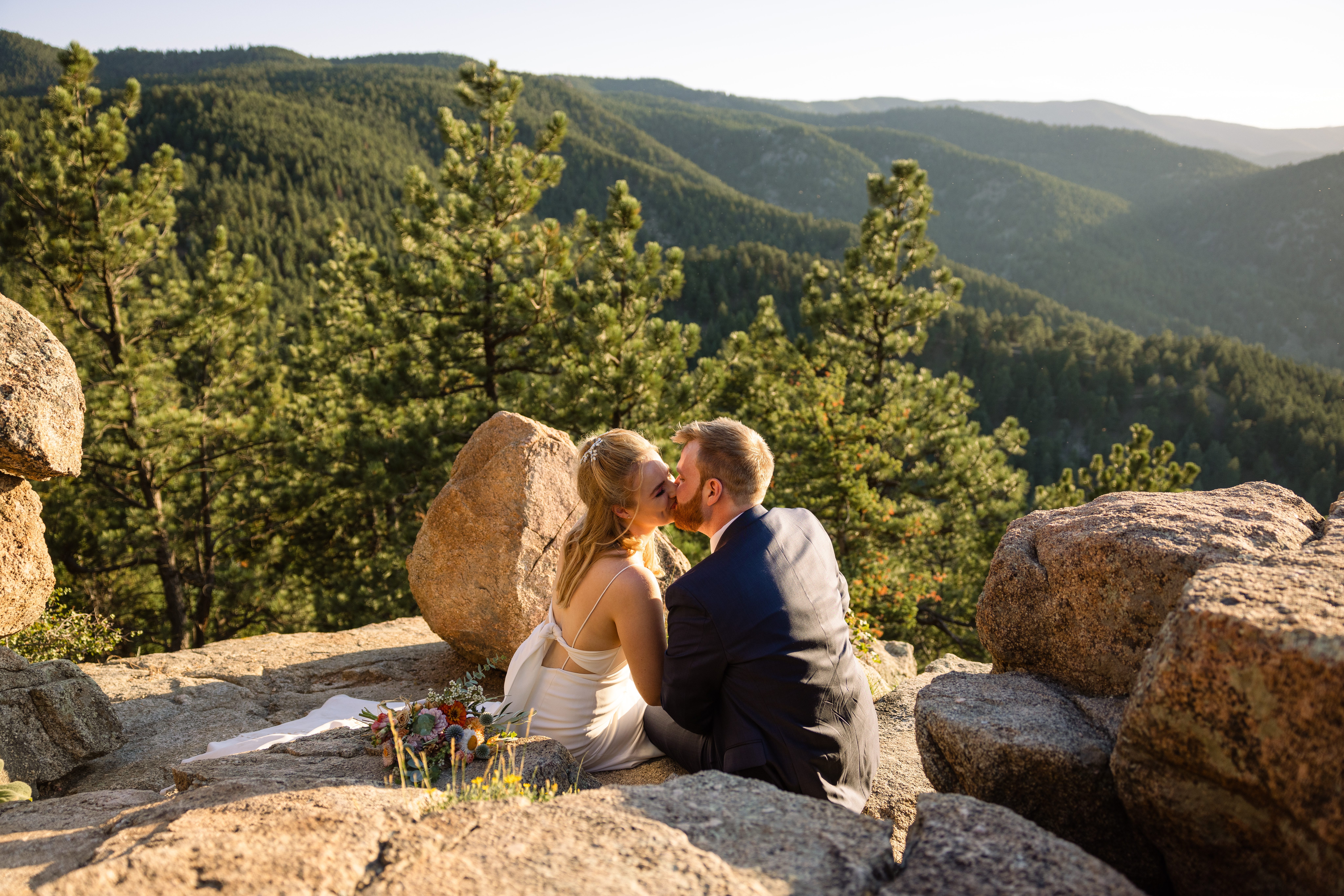 The bride and groom on top of the mountain kissing after reading notes to each other on their Sunrise Amphitheater wedding.