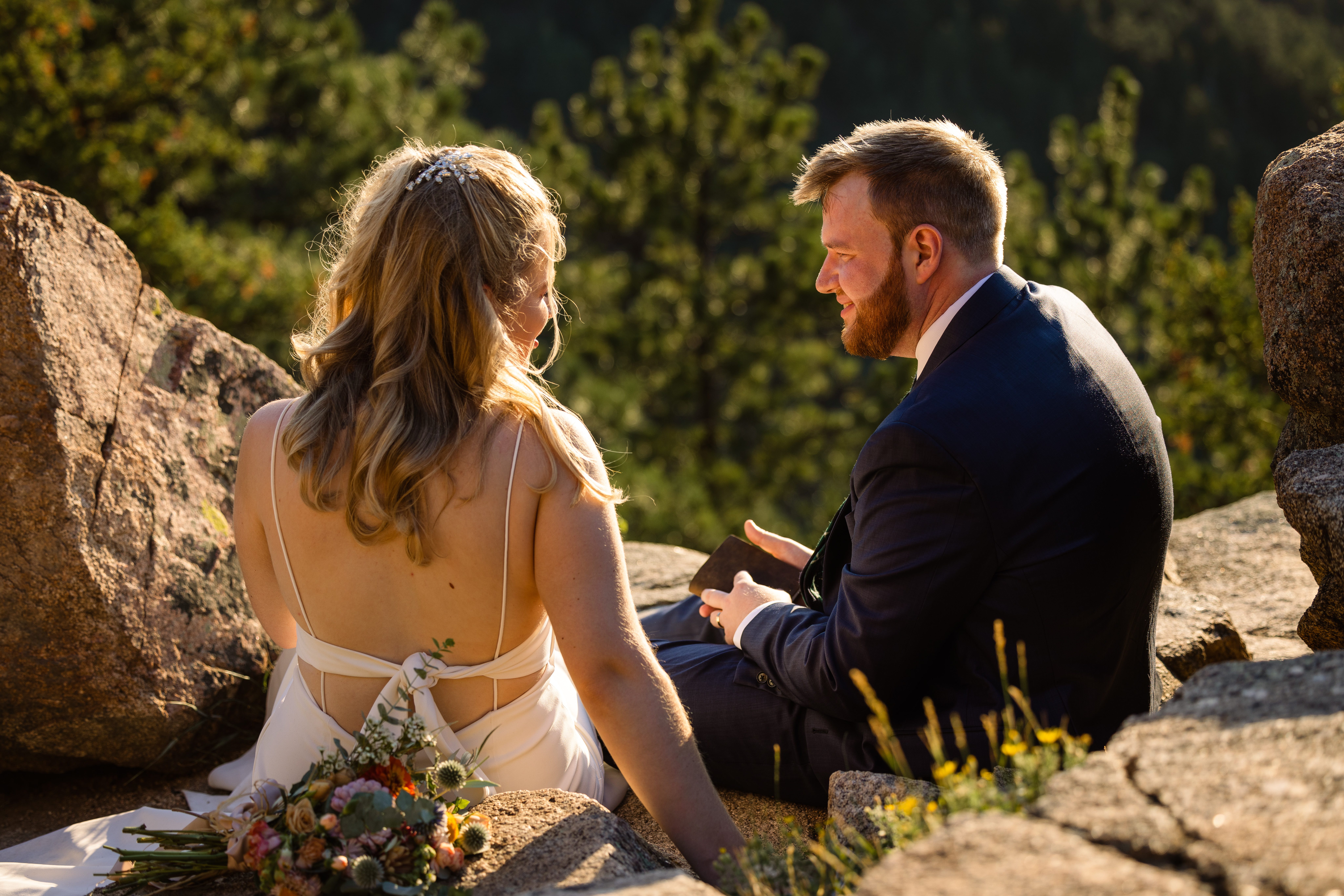 The bride and groom smiling at each other on top of the mountain after their Sunrise Amphitheater wedding.