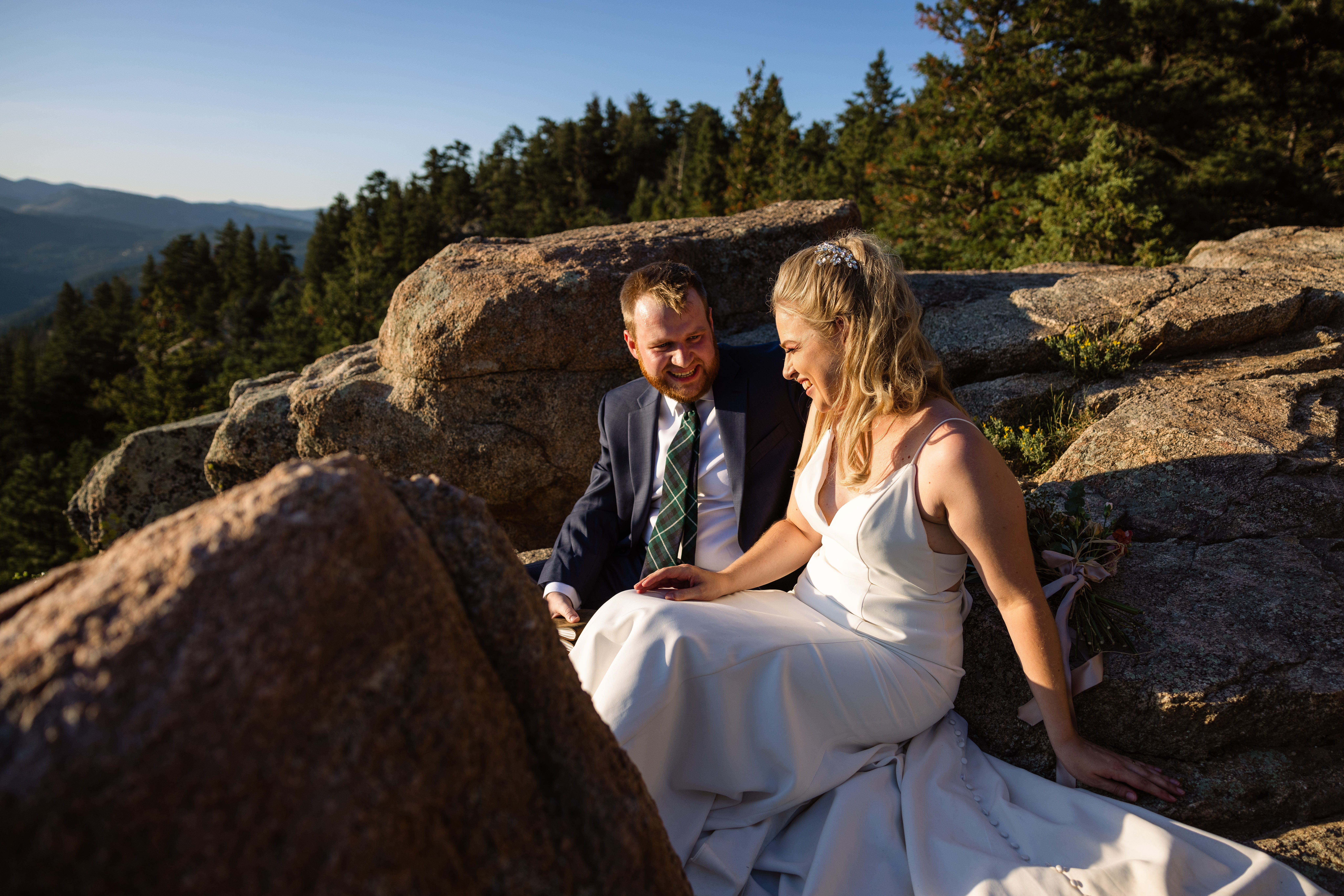 The bride and groom laughing together at sunset after their Sunrise Amphitheater wedding.