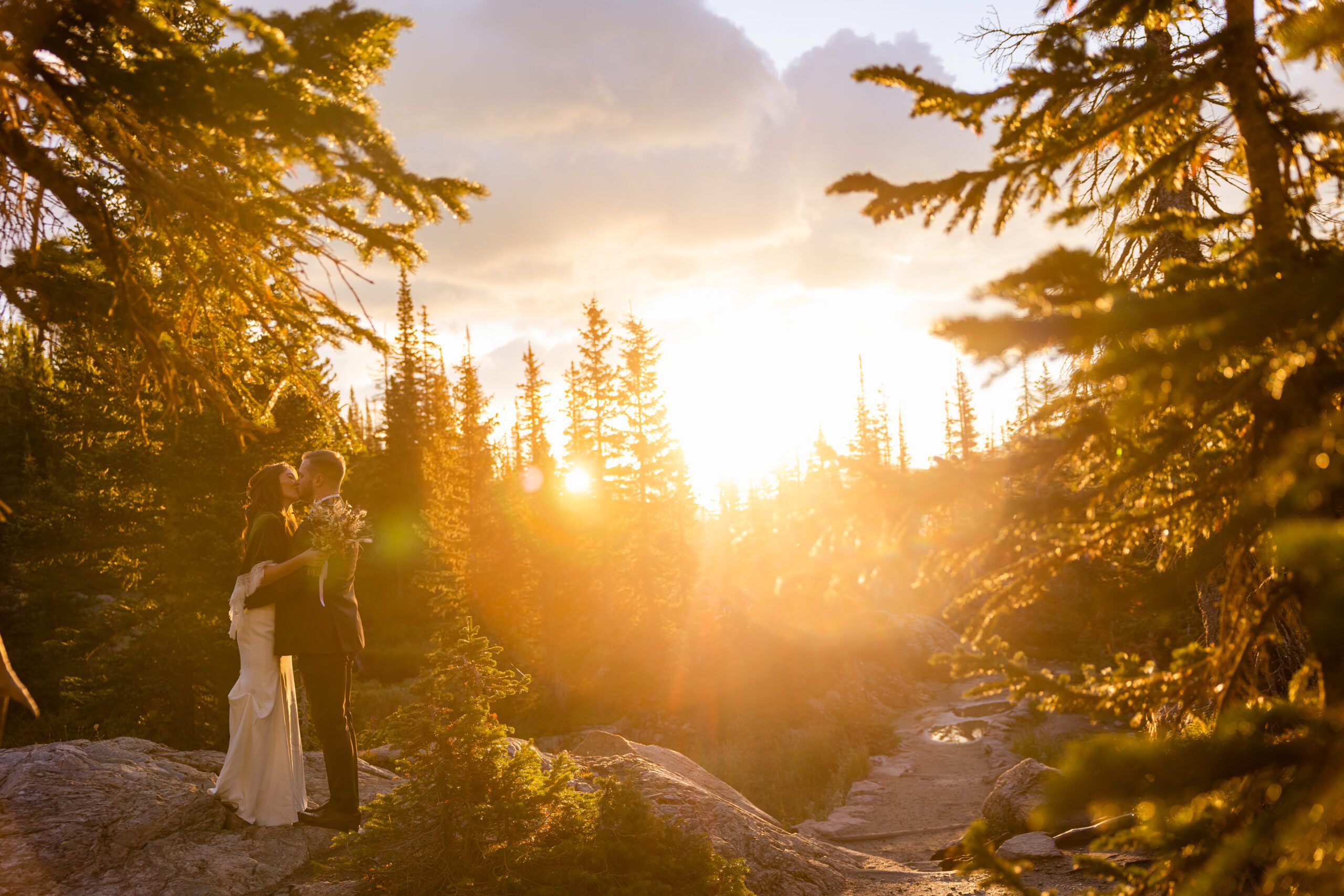 the bride and groom kissing as the sunrises at their Dream Lake elopement. 