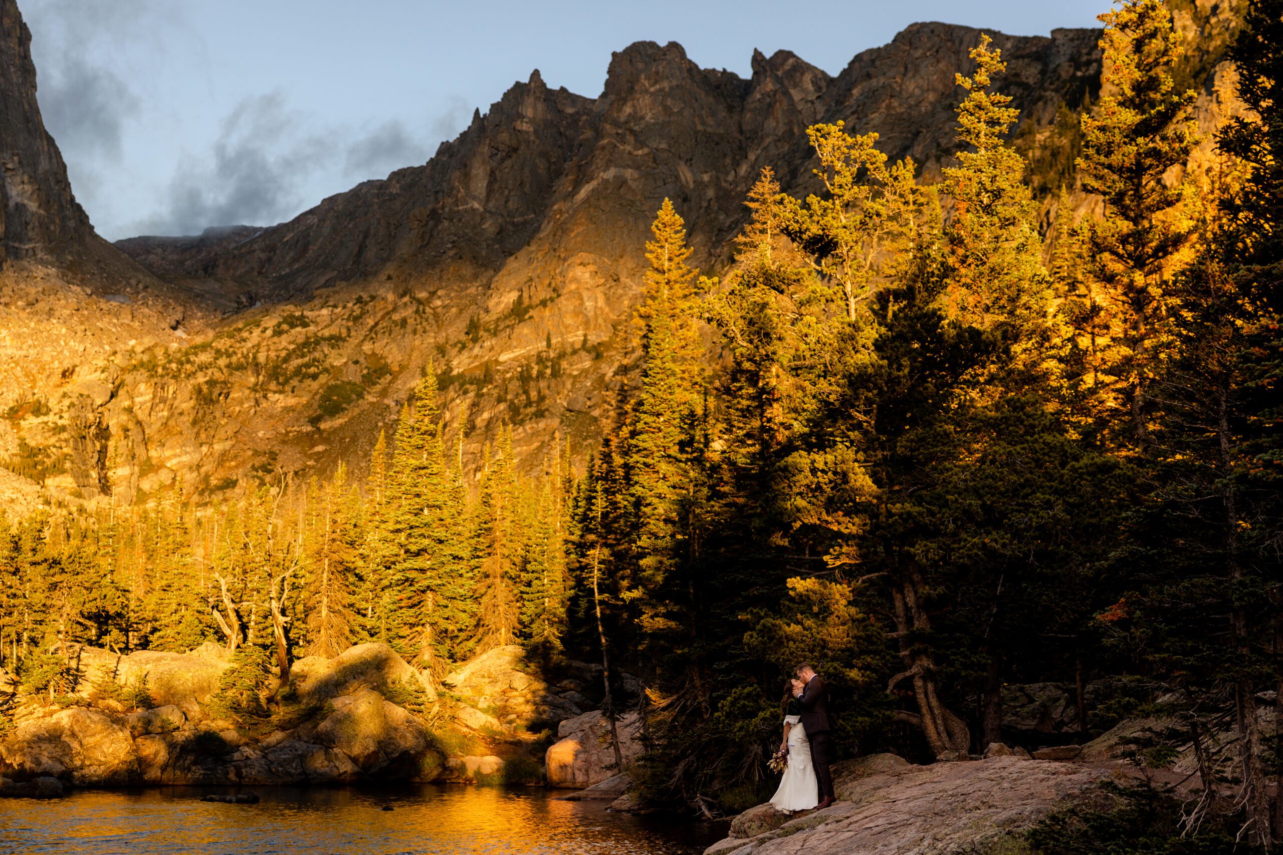 bride and groom kiss as the sun rises at their Dream Lake elopement. 