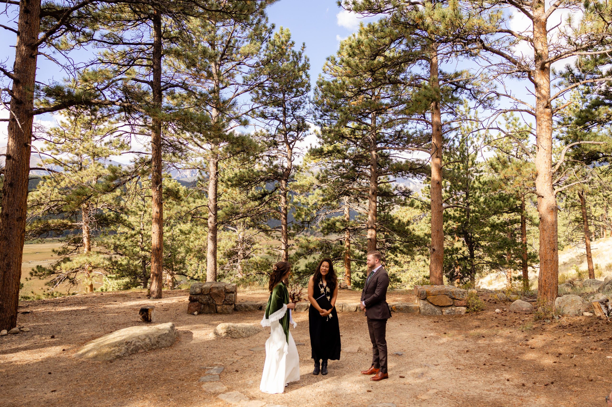 the bride and groom at the altar with the officiant at Moraine Park Amphitheater on their Dream Lake elopement day. 