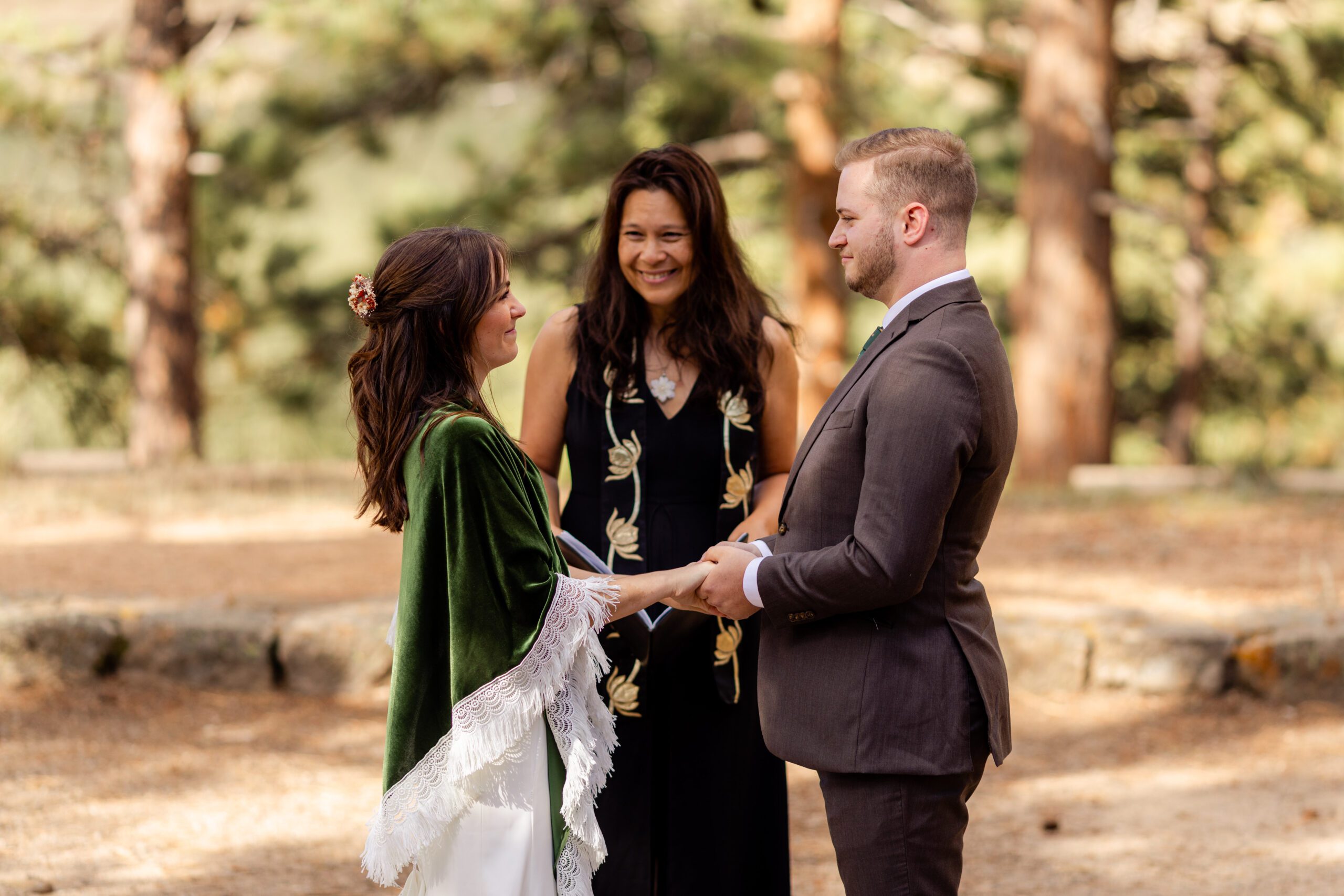 the bride and groom holding hands at the alter at their Dream Lake elopement ceremony. 