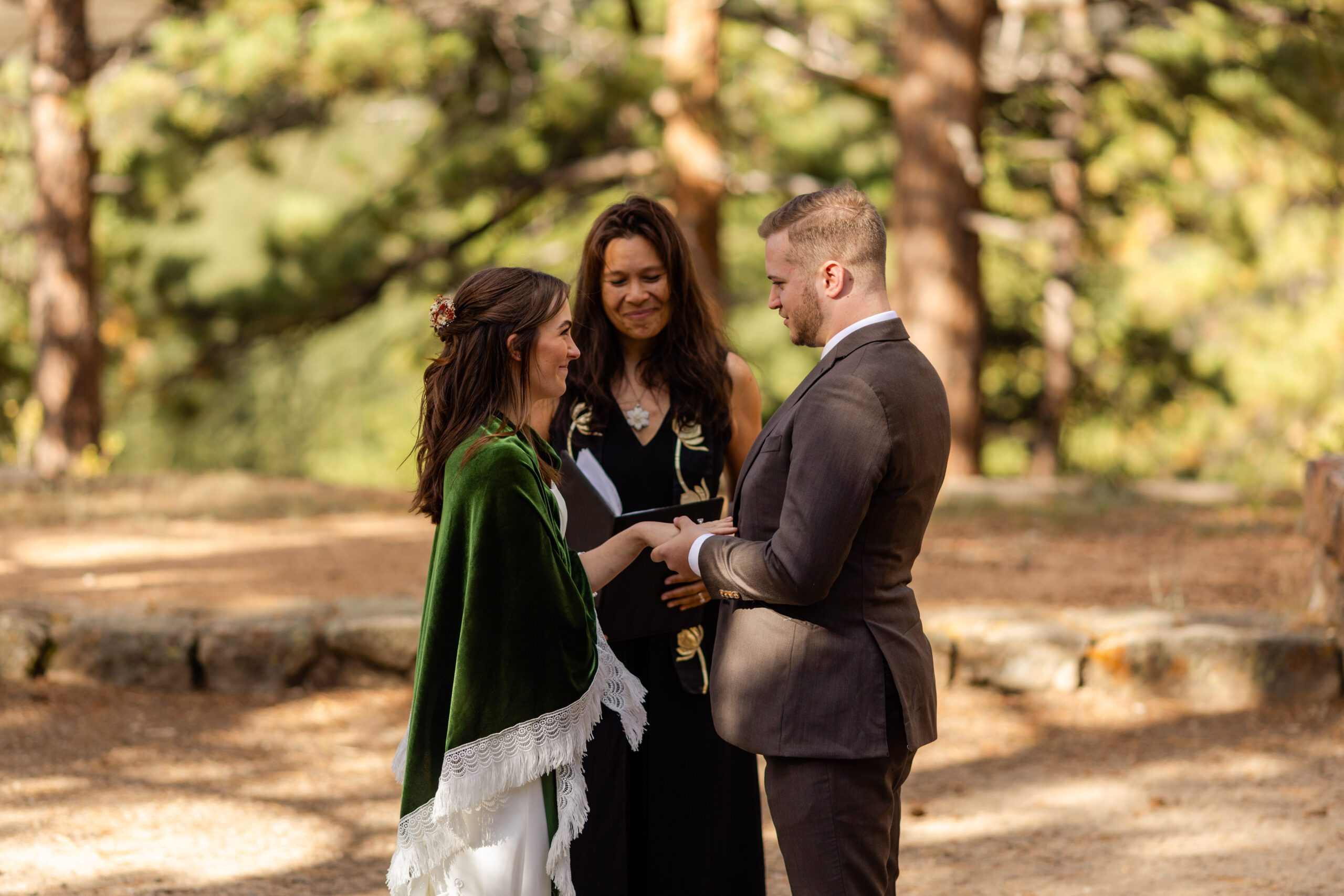 groom places ring on his brides hand during their Dream Lake elopement ceremony. 