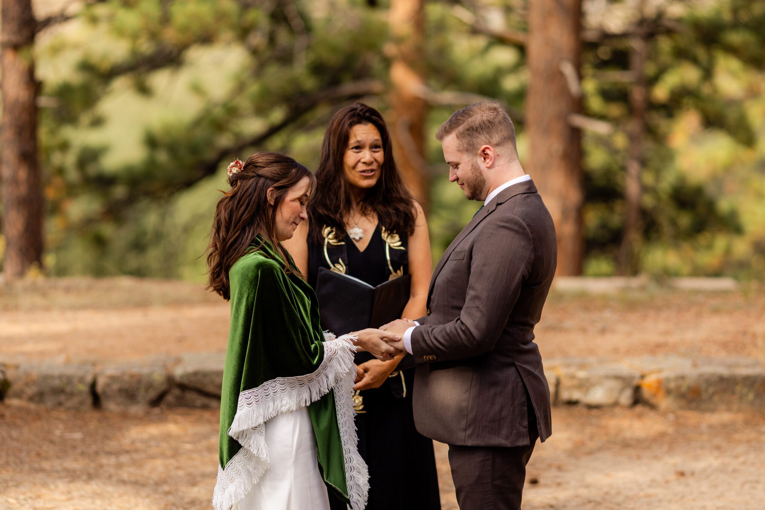 bride places ring on her grooms hand during their Dream Lake elopement.