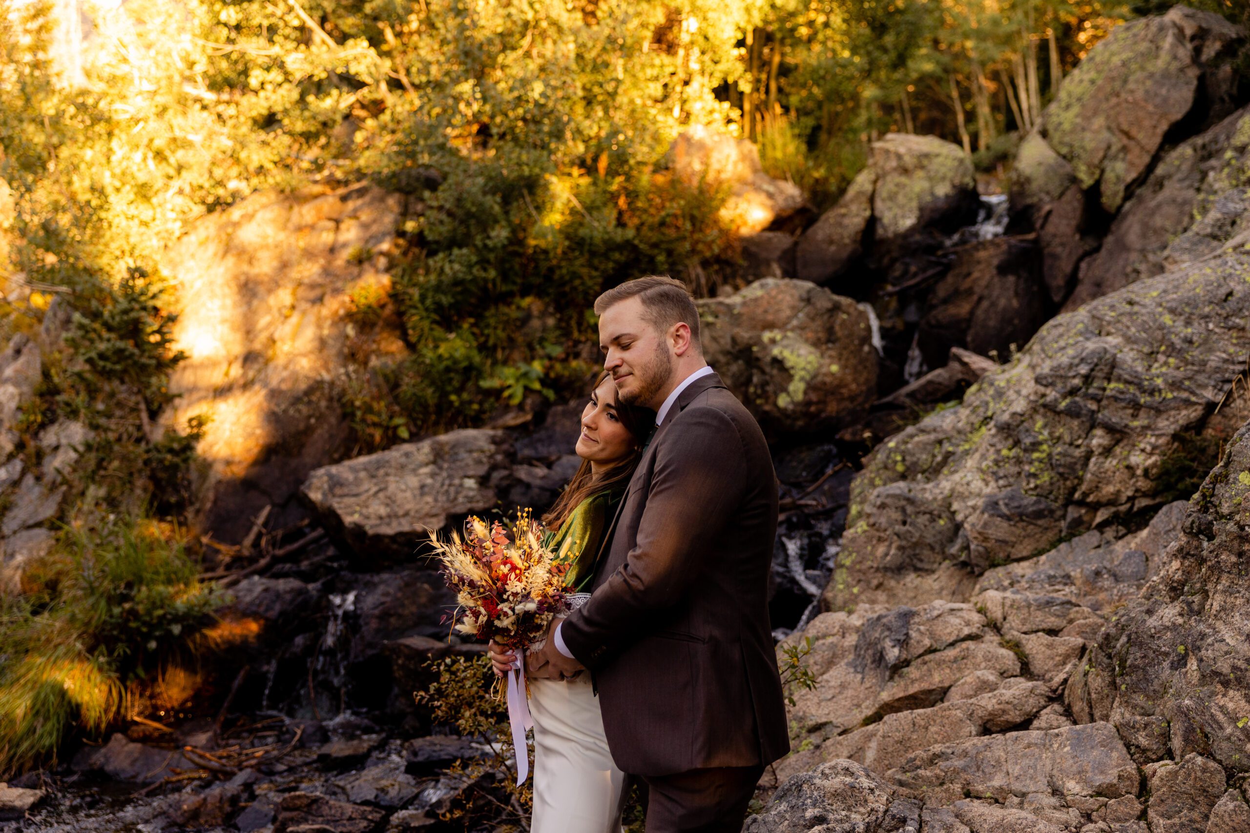 groom wraps his arms around his bride at their dream lake elopement. 