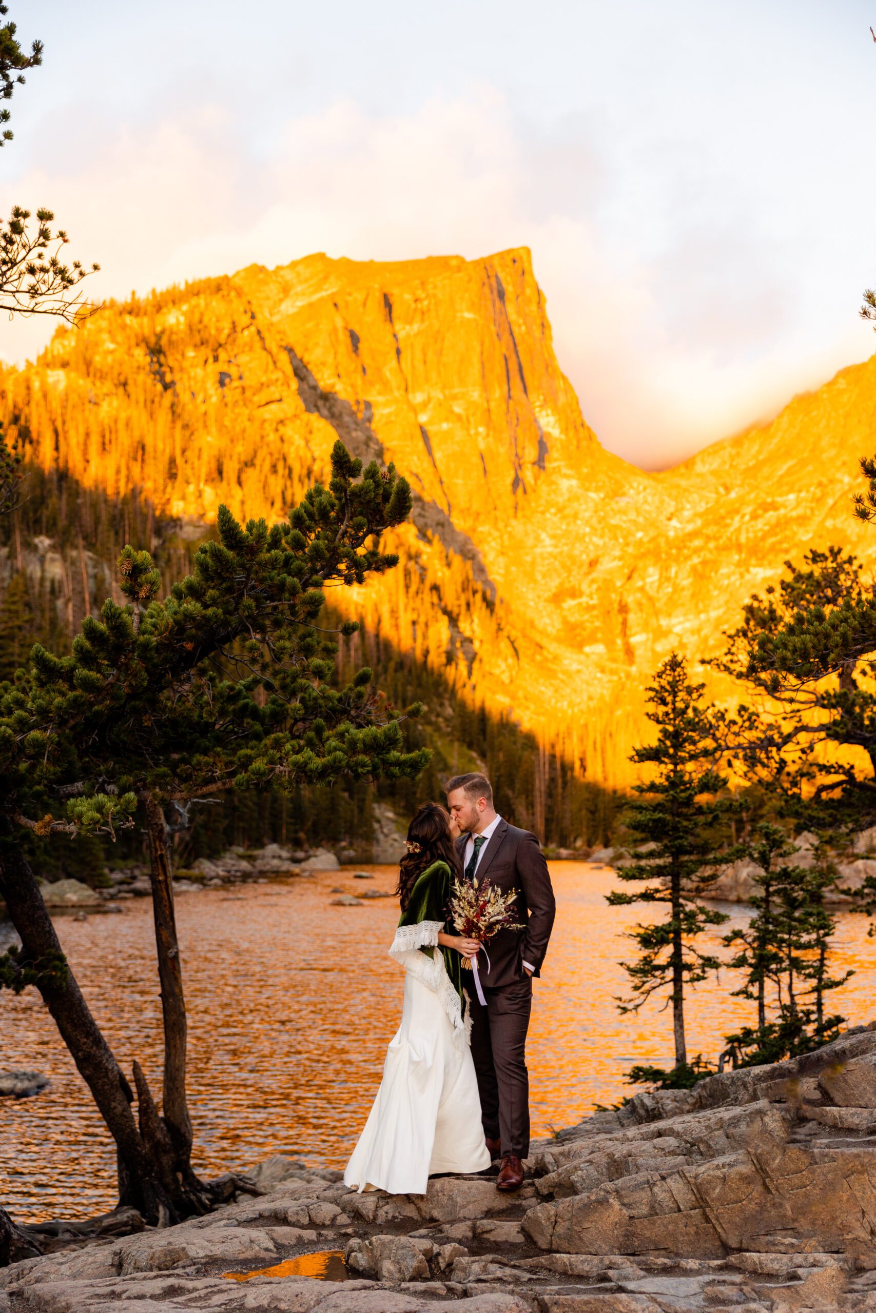 bride and groom kissing near the lake at their Dream Lake elopement. 