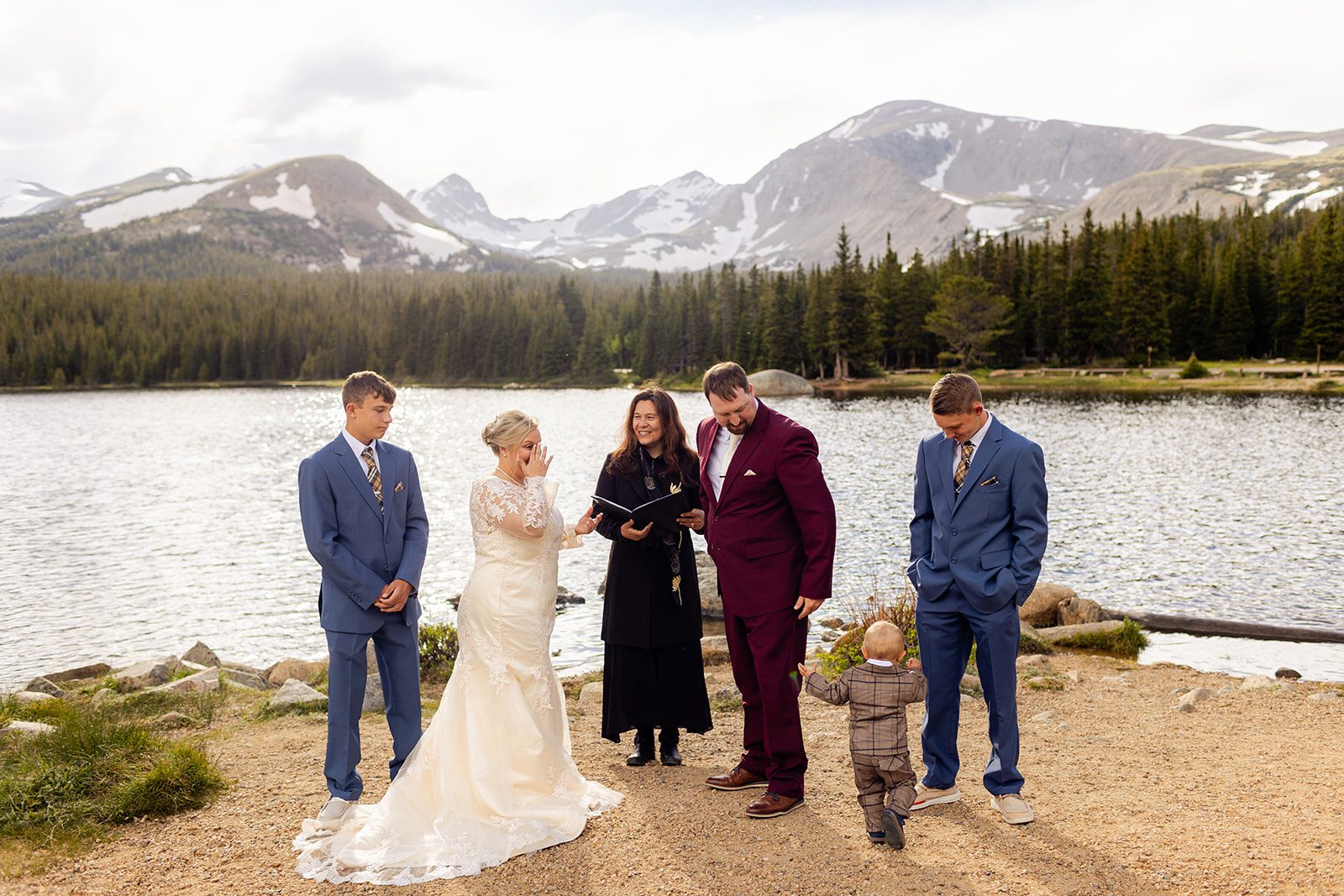 the couple with their boys and the officiant on a sunny day at brainard lake for their wedding.