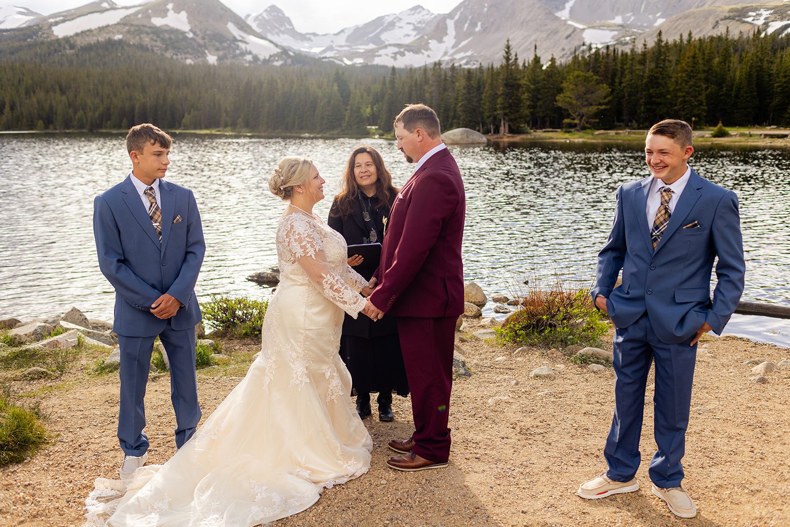 bride and groom holding hands and smiling during their Brainard Lake ceremony.
