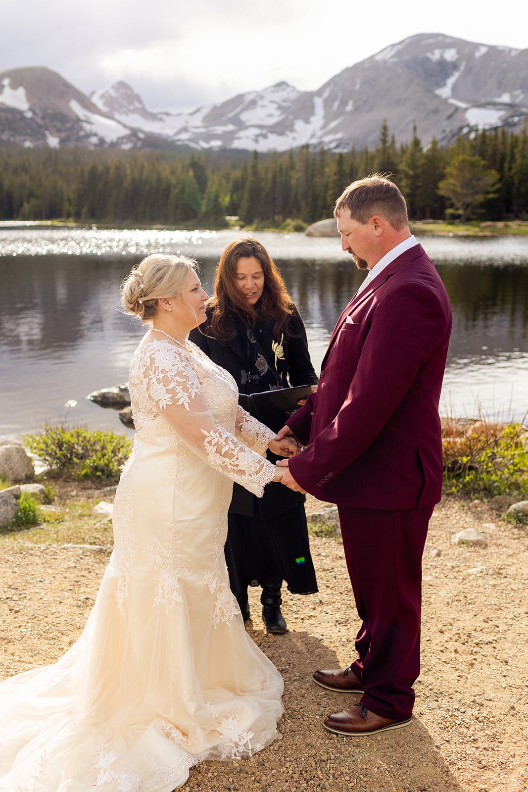 Bride and groom holding hands during their ceremony at Brainard Lake.