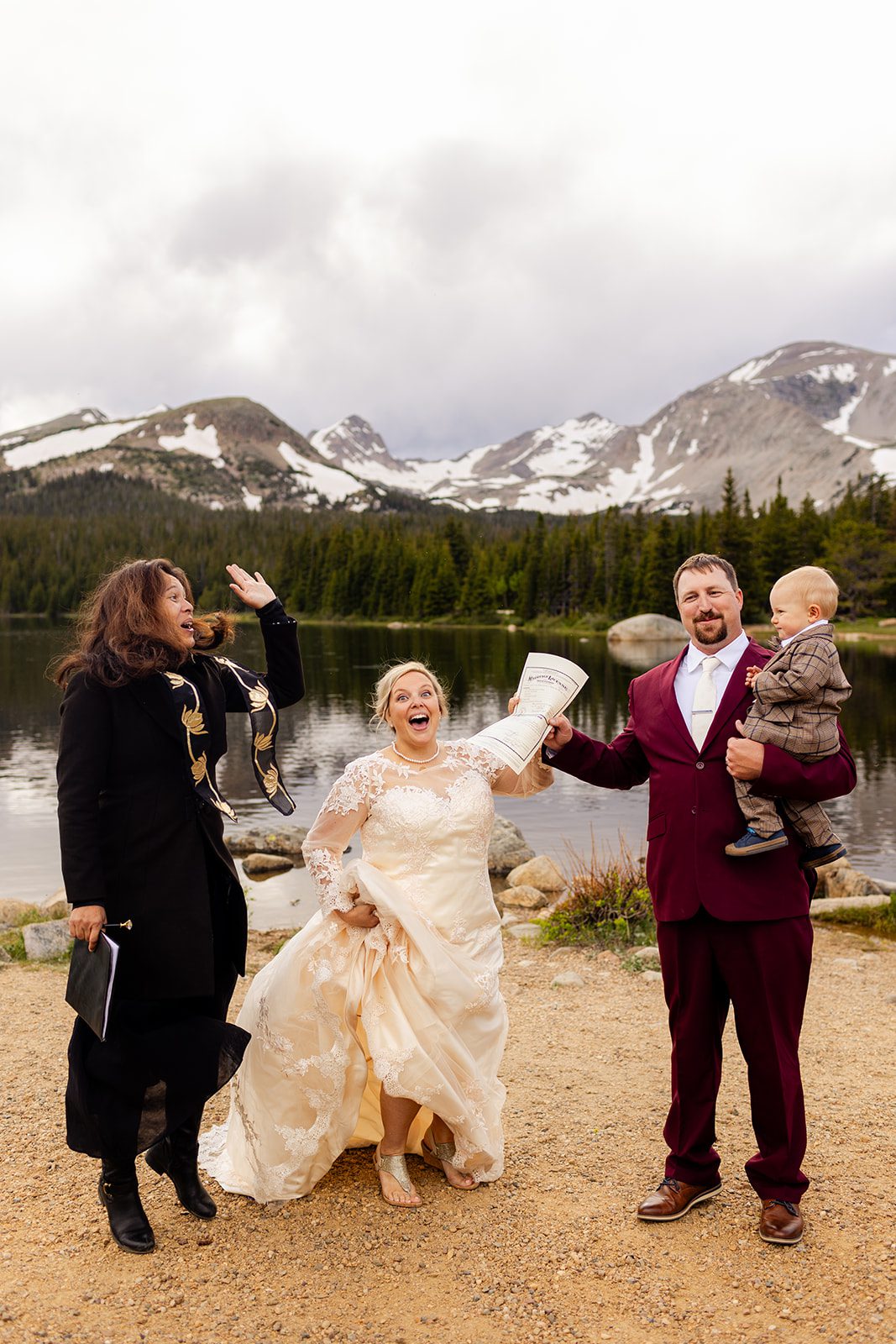 bride, groom, officiant and their little son celebrate after their Brainard Lake wedding ceremony.