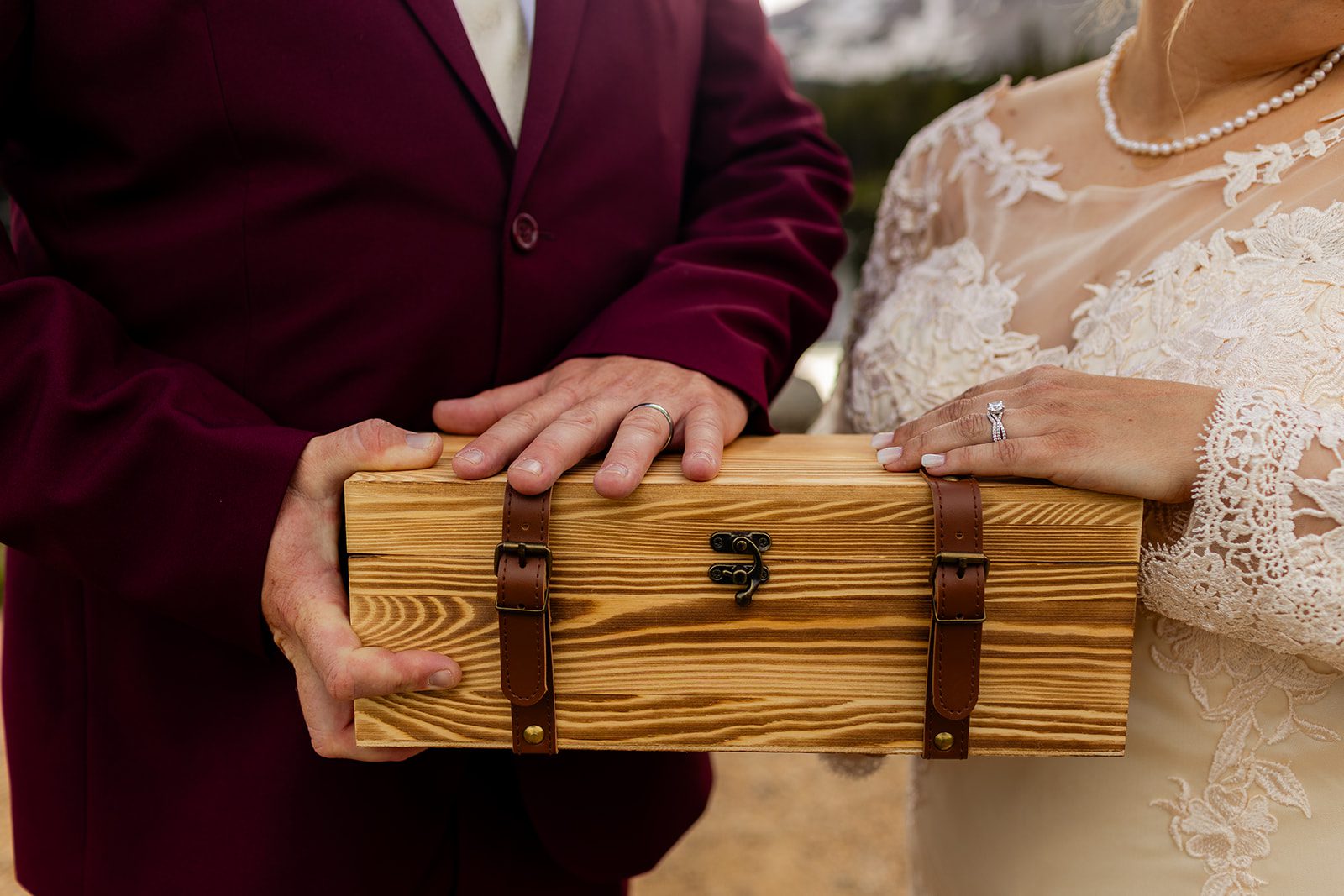 Bride and groom holding a wine box.