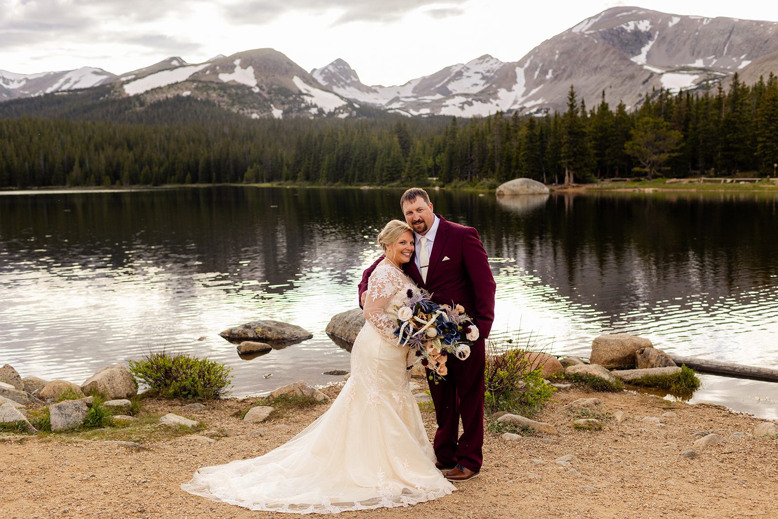 bride and groom smile next to Brainard Lake.