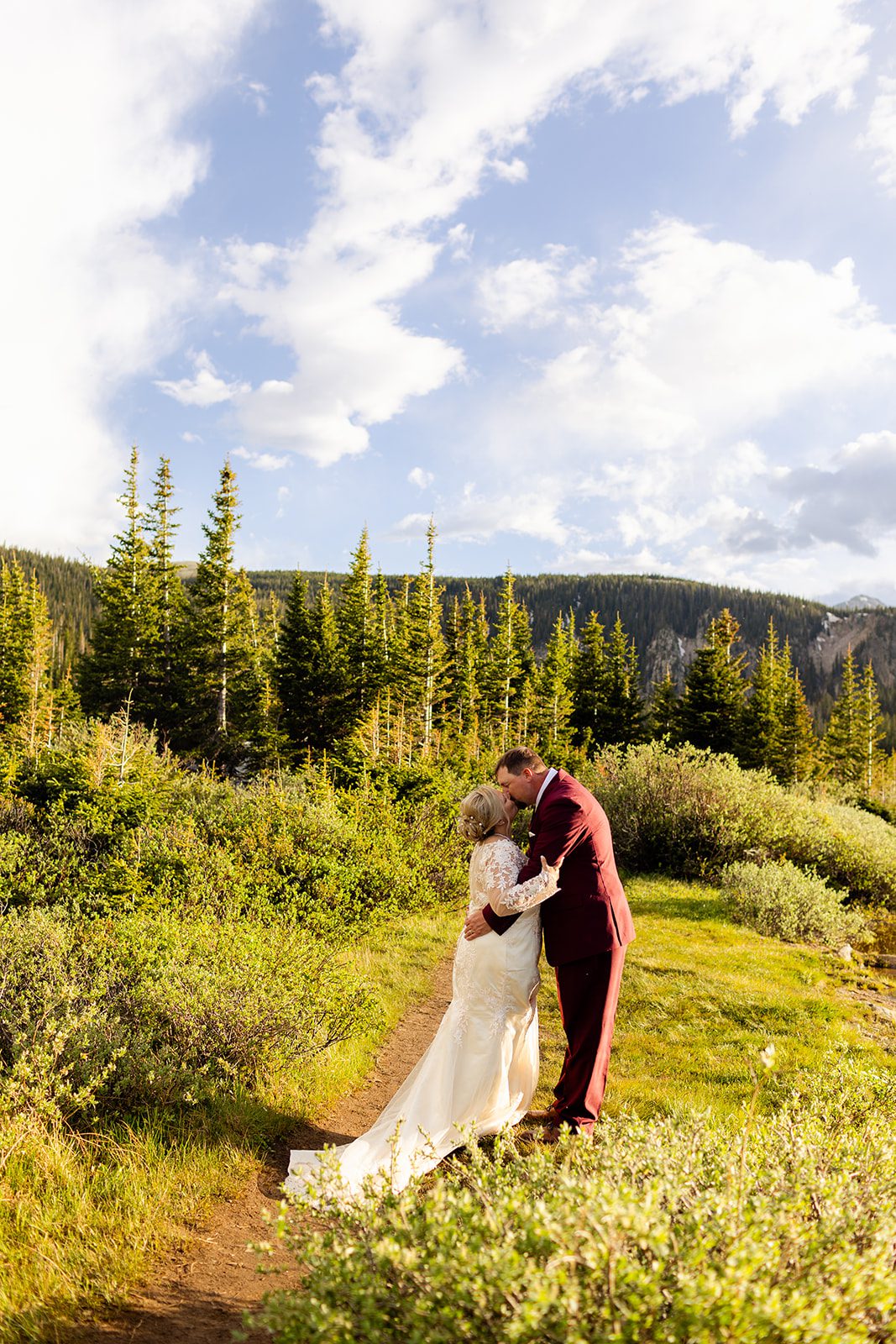 Bride and groom kissing in a field near, Brainard Lake.