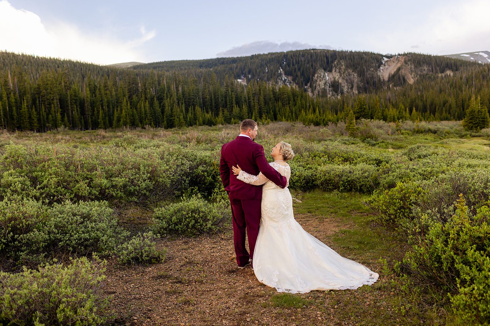 Bride and groom holding each other after their wedding ceremony in the field by Brainard Lake.