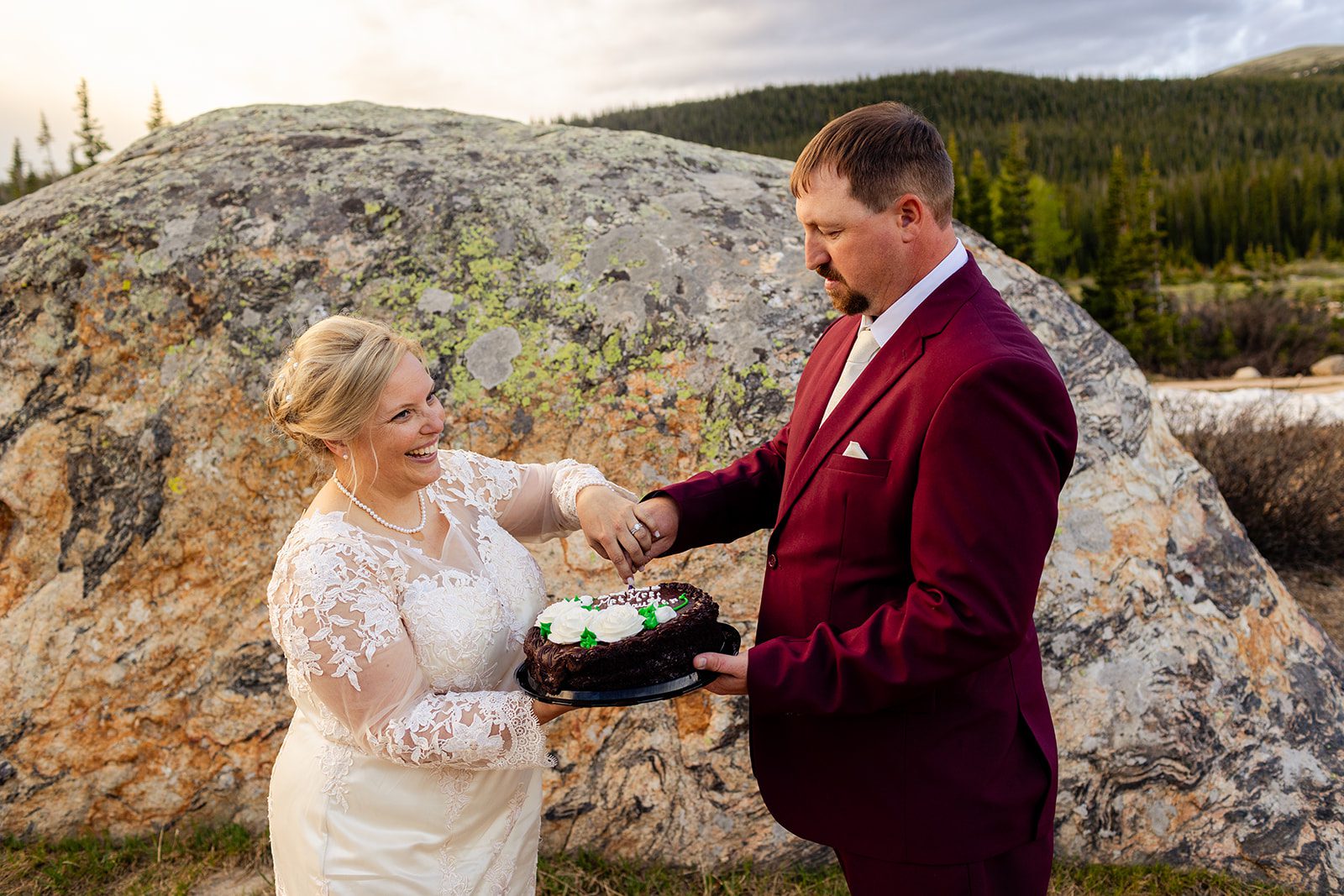 bride and groom cutting a cake after their Brainard Lake wedding.