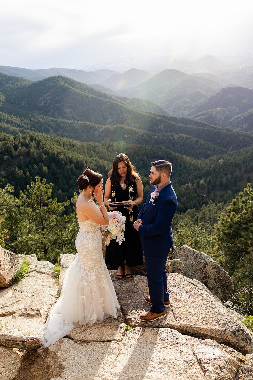 bride wipes a tear from her eye during  their Boulder elopement ceremony with videography.