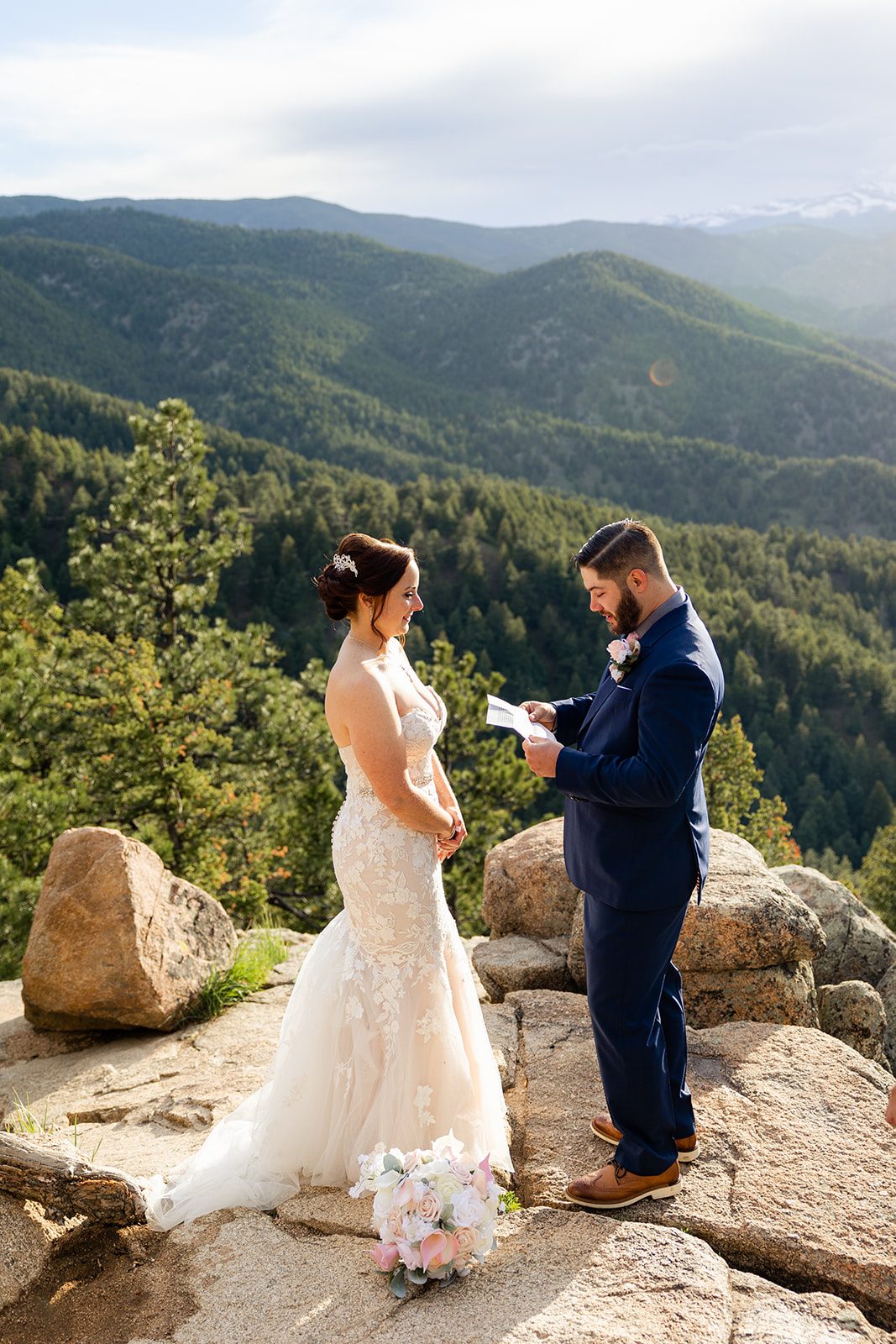 bride looks sweetly at her groom while he reads his vow during their  their Boulder ceremony elopement with videography.