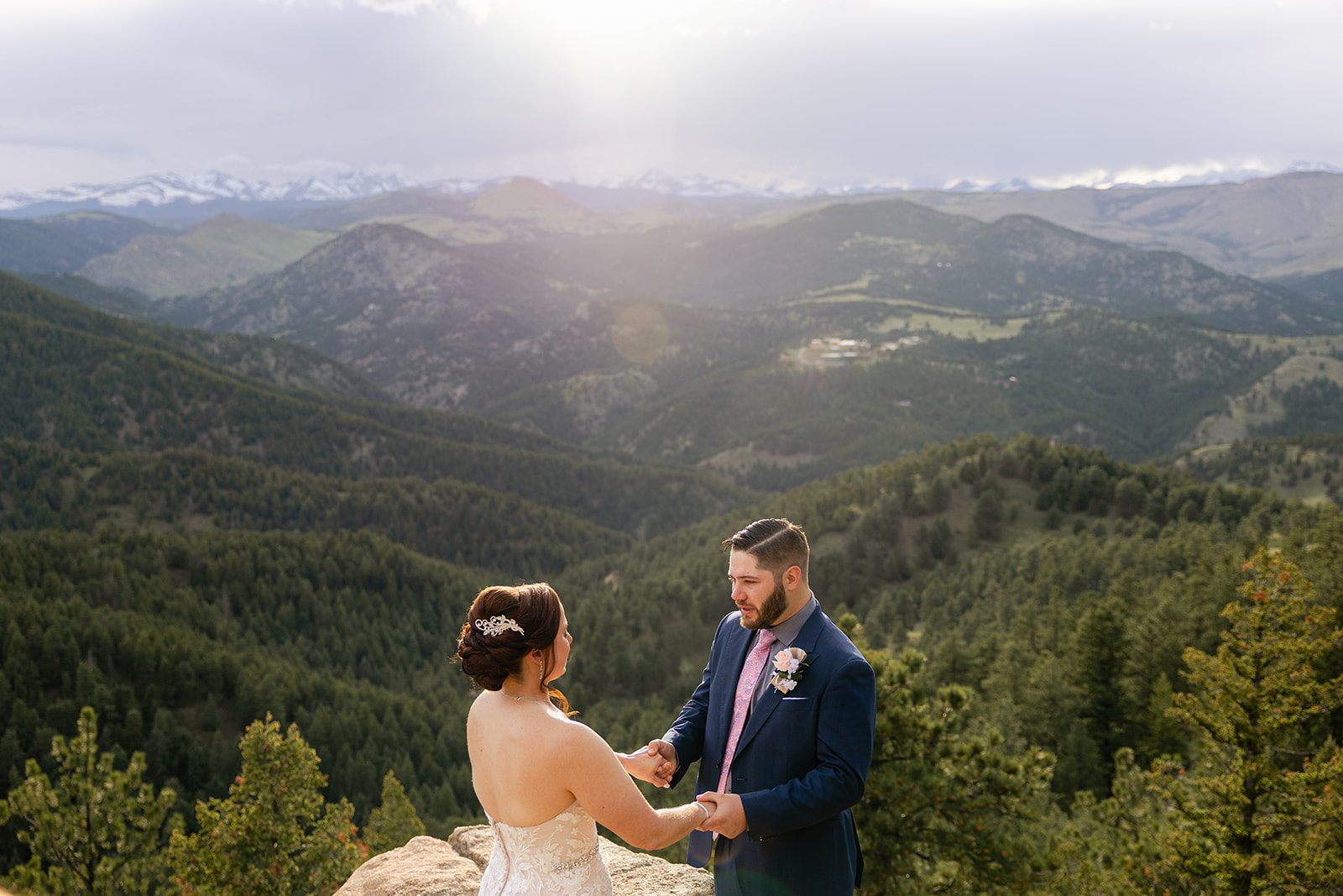 bride and groom holding hands during their ceremony at  their Boulder elopement with videography.