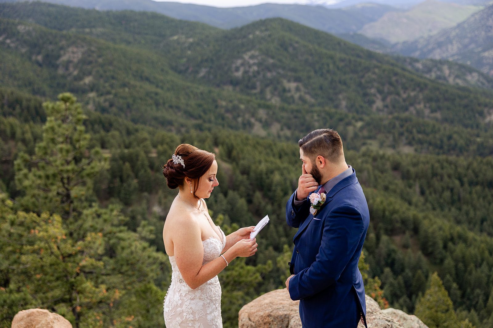 Groom wiping his tear as his bride reads her vows during  their Boulder elopement ceremony with videography.