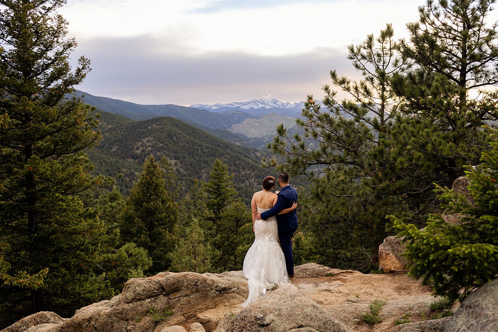 bride and groom looking out at the rocky mountains during their Boulder elopement with videography.