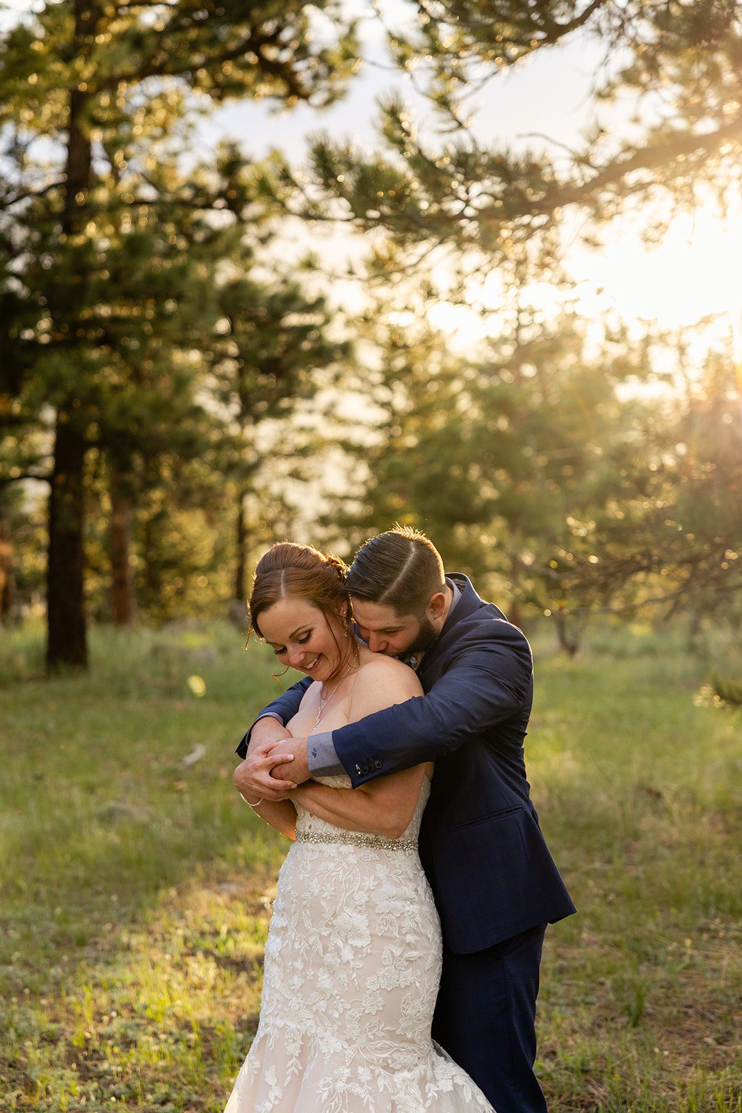 groom kisses his bride on the back during their Boulder elopement with videography.