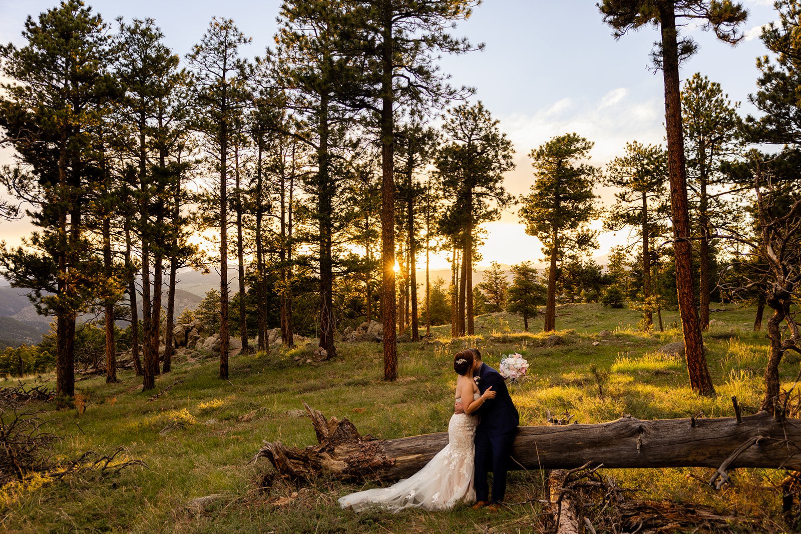 bride and groom kissing at sunset in a meadow at their Boulder elopement with videography.