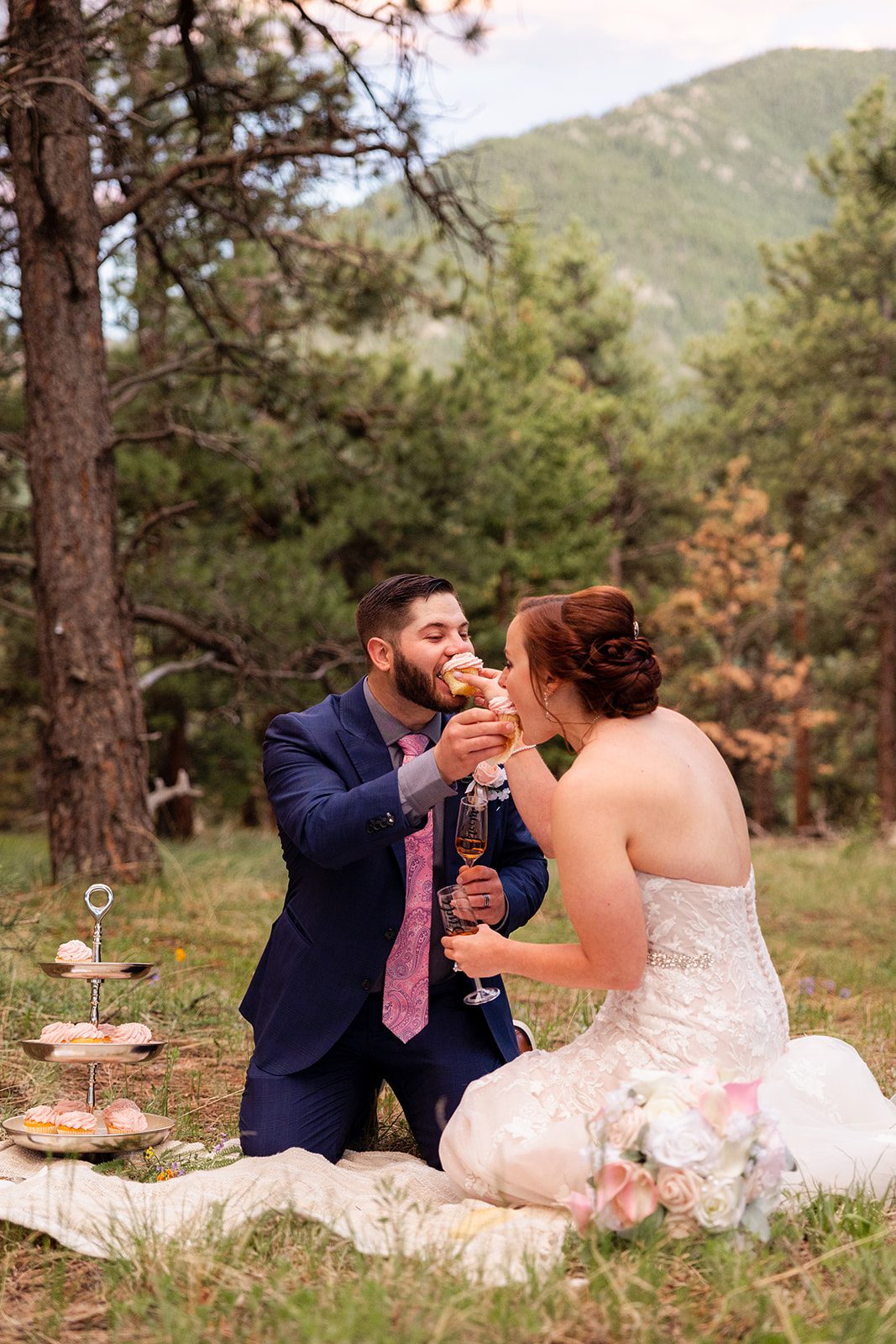 groom feeds a cupcake to his bride as she feeds him one at their Boulder elopement with videography.