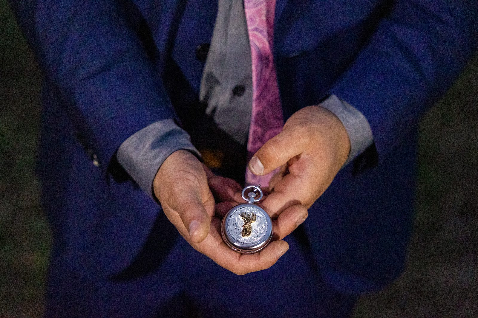 Groom holding personal pocket watch during their Boulder elopement with videography.