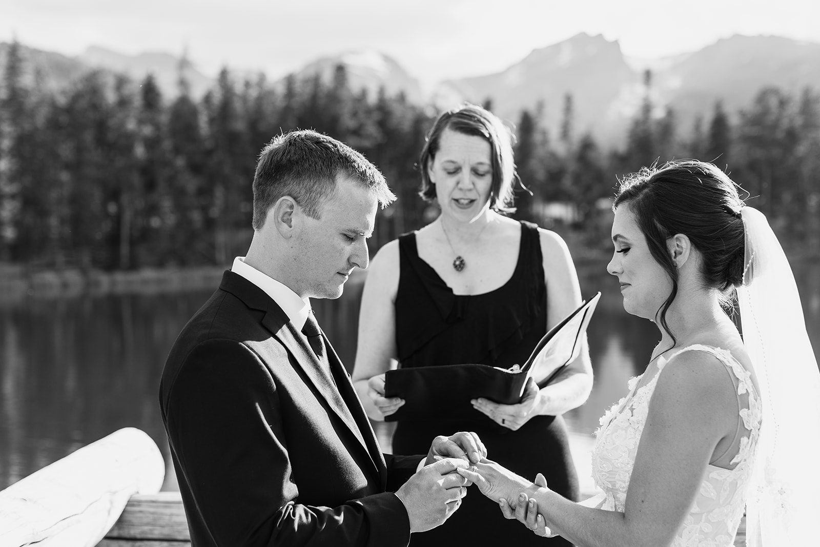 Black and white photo of groom placing ring on bride's hand
