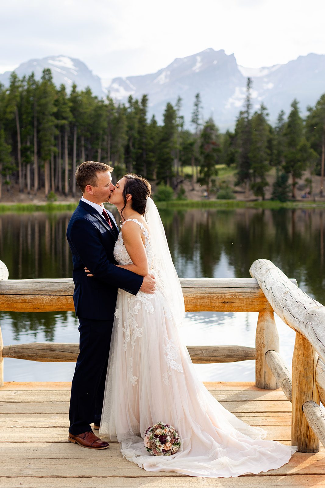 Bride and groom kiss for the first time at their sprague lake summer elopement.