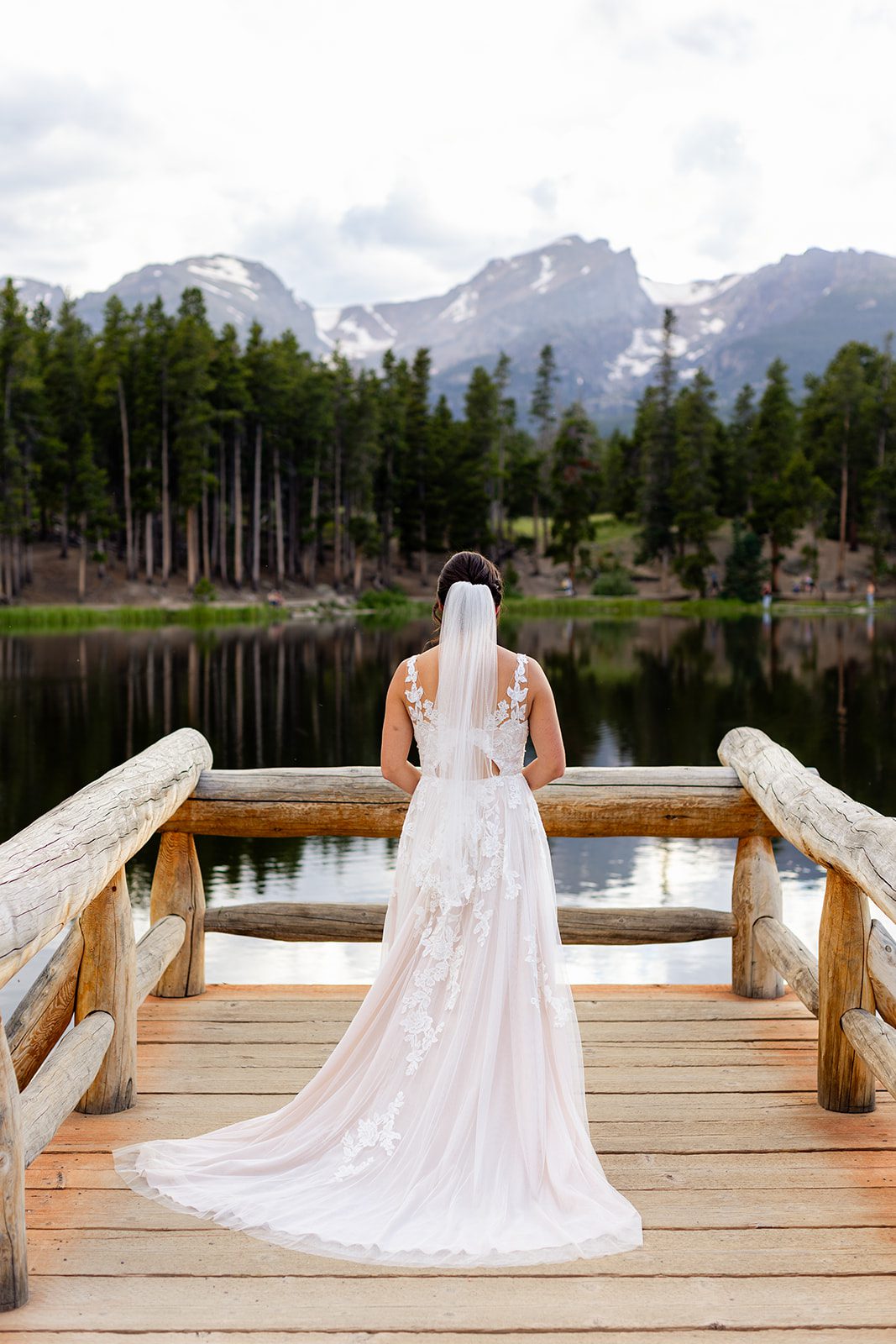 Bride in white wedding dress with veil on Sprague Lake