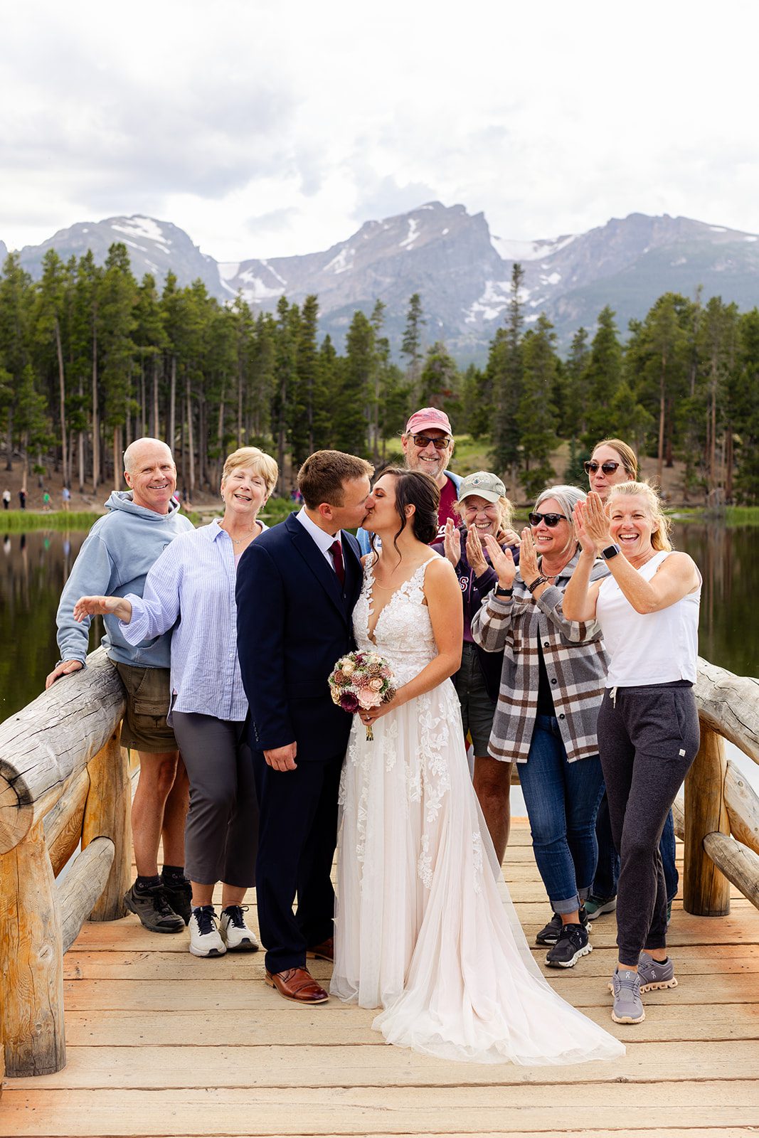 bride and groom kissing amongst strangers at Sprague Lake