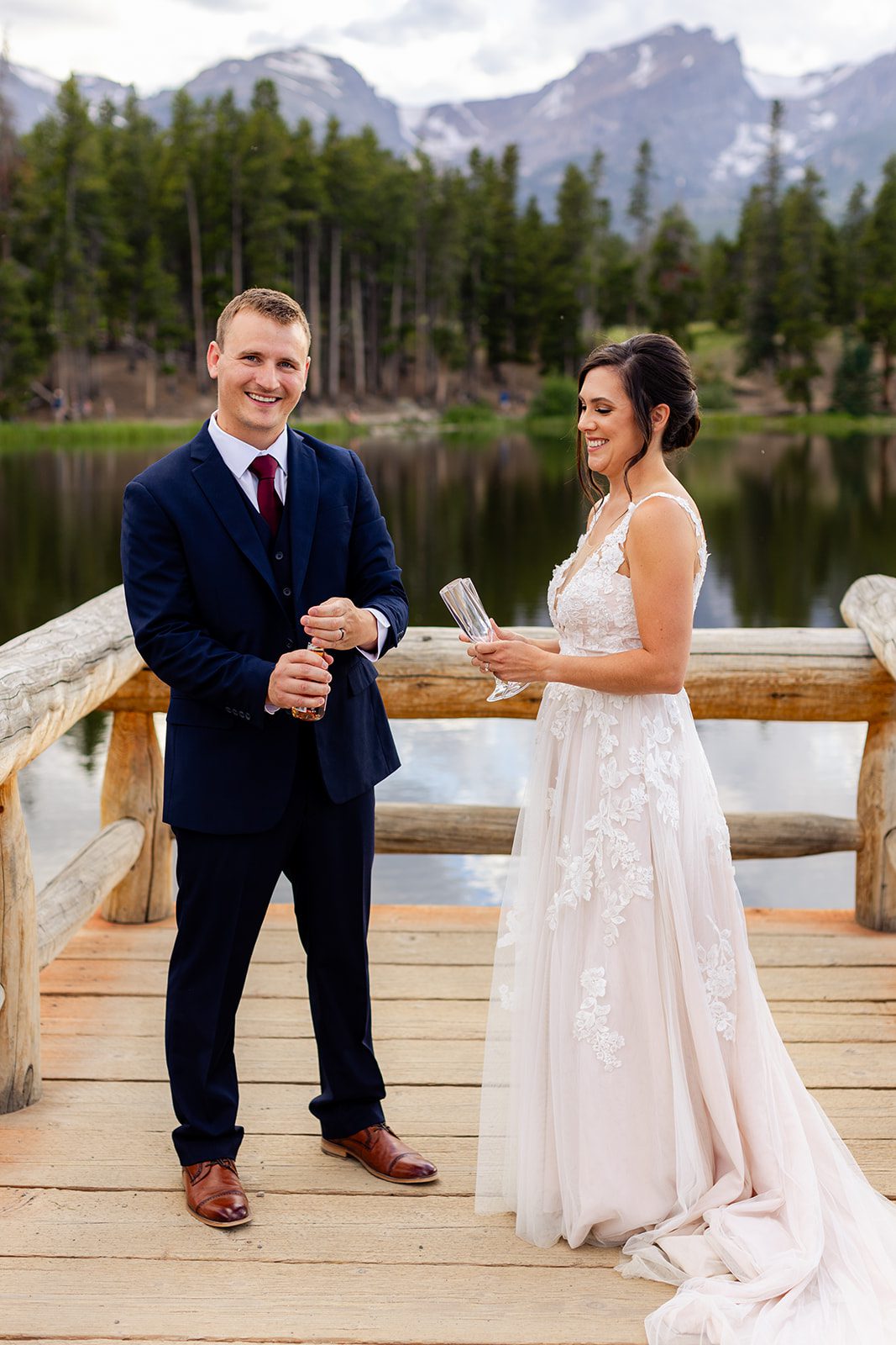 Groom opening champag bottle to celebrate after their elopement ceremony at Sprague Lake
