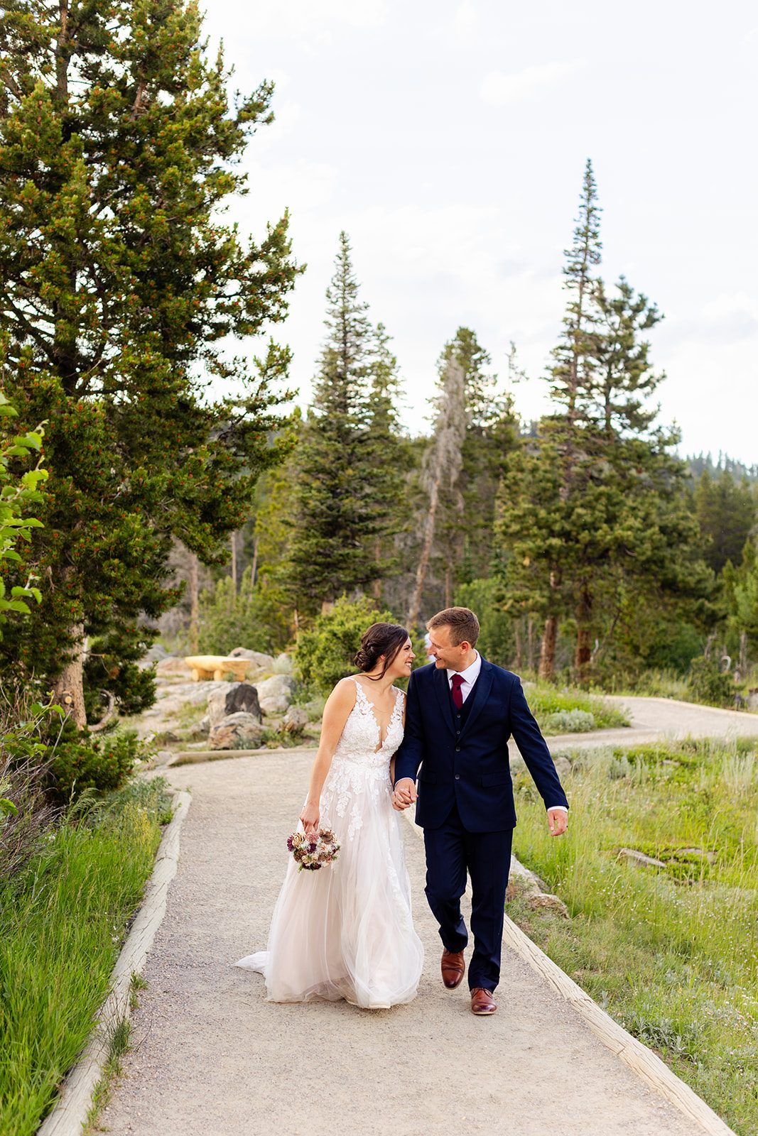 bride and groom walking together after their sprague lake elopement ceremony.