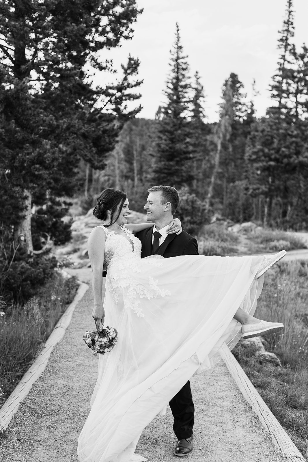 Groom holding his bride, black and white photo, after their Sprague Lake elopement ceremony