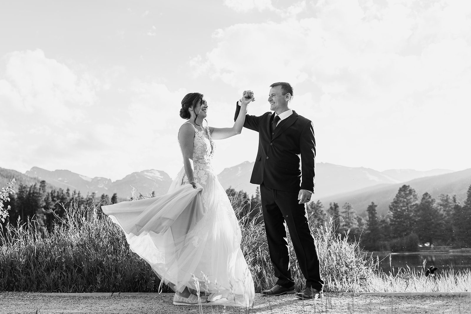 black and white photo of bride and groom dancing next to Sprague Lake during their elopement