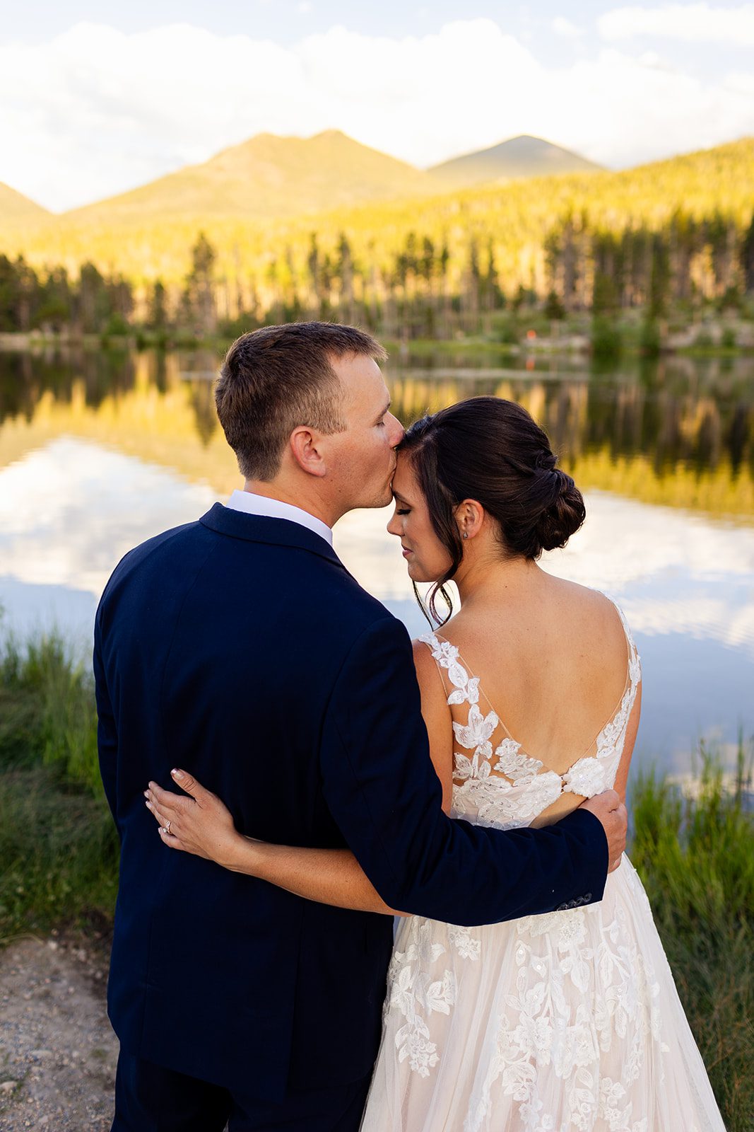 Groom kissing bride forehead for Sprague Lake Elopement ceremony