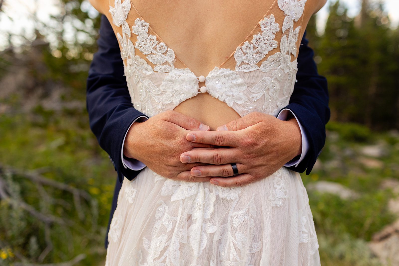 Groom wraps arms around bride in white dress